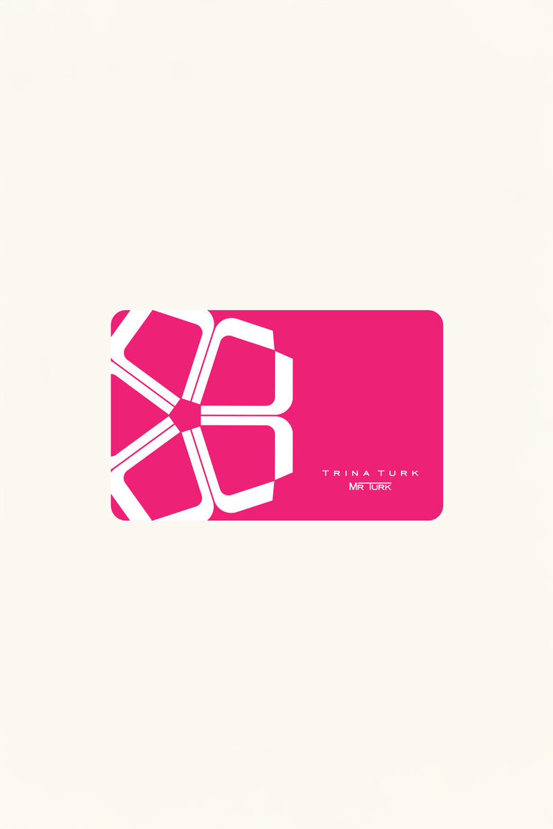 A pink rectangular Trina Turk Gift Card features a white abstract geometric flower on the left, with “Trina Turk Mr Turk” in small white letters in the bottom right corner. The card is set against a plain off-white background.