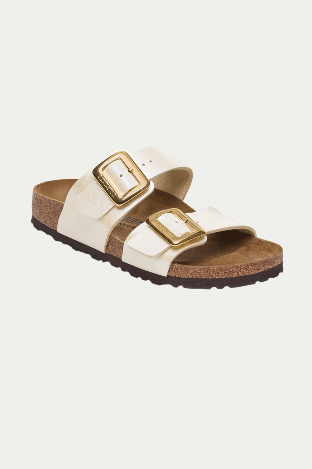 The Womens Sydney Luxe Buckle Sandal in Pearl features two wide straps with large gold buckles, a cork footbed, and a dark textured sole.