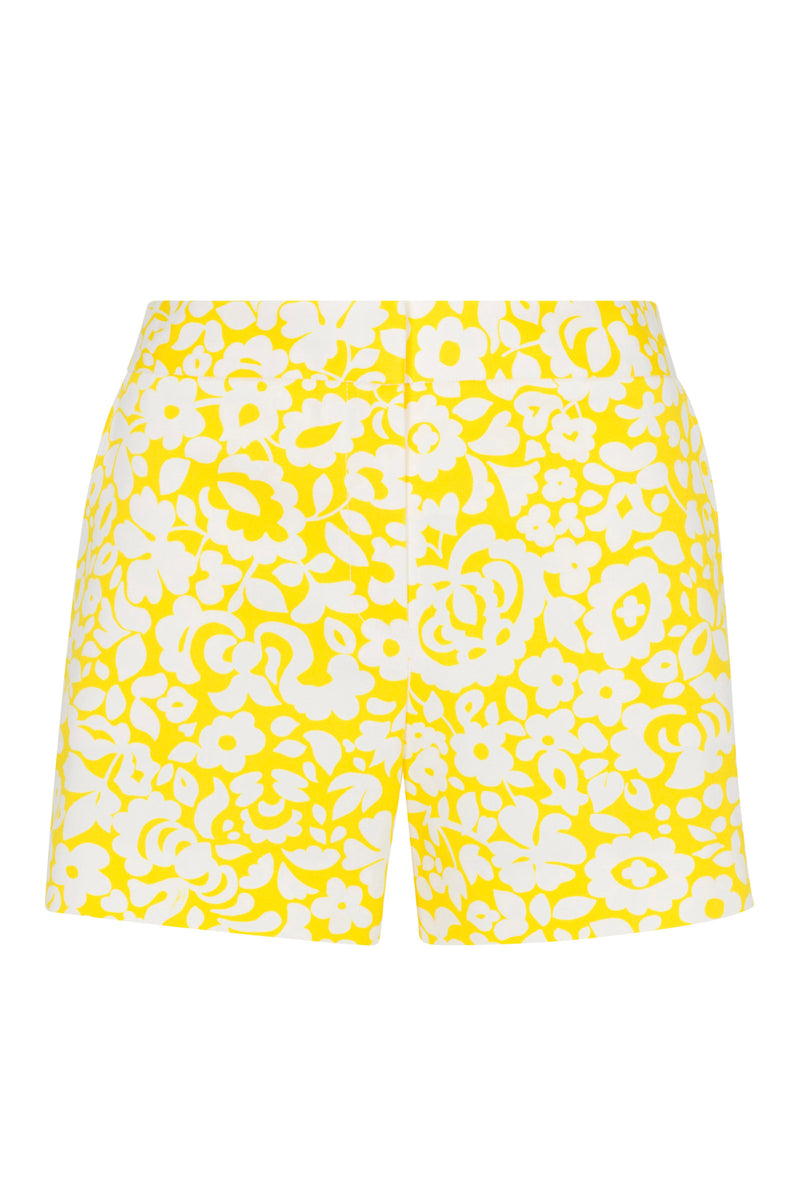 The Corbin 2 Shorts - Poolside Gossip feature a high-waisted, tailored fit with a bold yellow and white floral print of stylized flowers and leaves. These shorts have a clean look with no visible waistband or pockets.