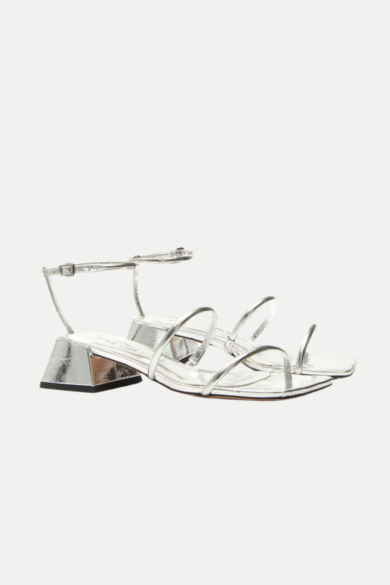 Burano Silver Strappy Heeled Sandal: A pair of silver sandals with low geometric block heels and ankle straps, shown on a white background.