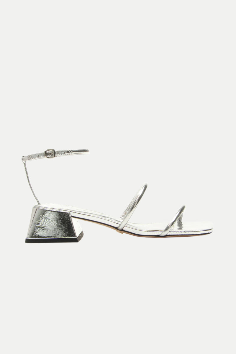 The Burano Silver Strappy Heeled Sandal features a silver finish, open toe, low block heel, thin straps across the toe and instep, plus an ankle strap with buckle, shown on a white background.