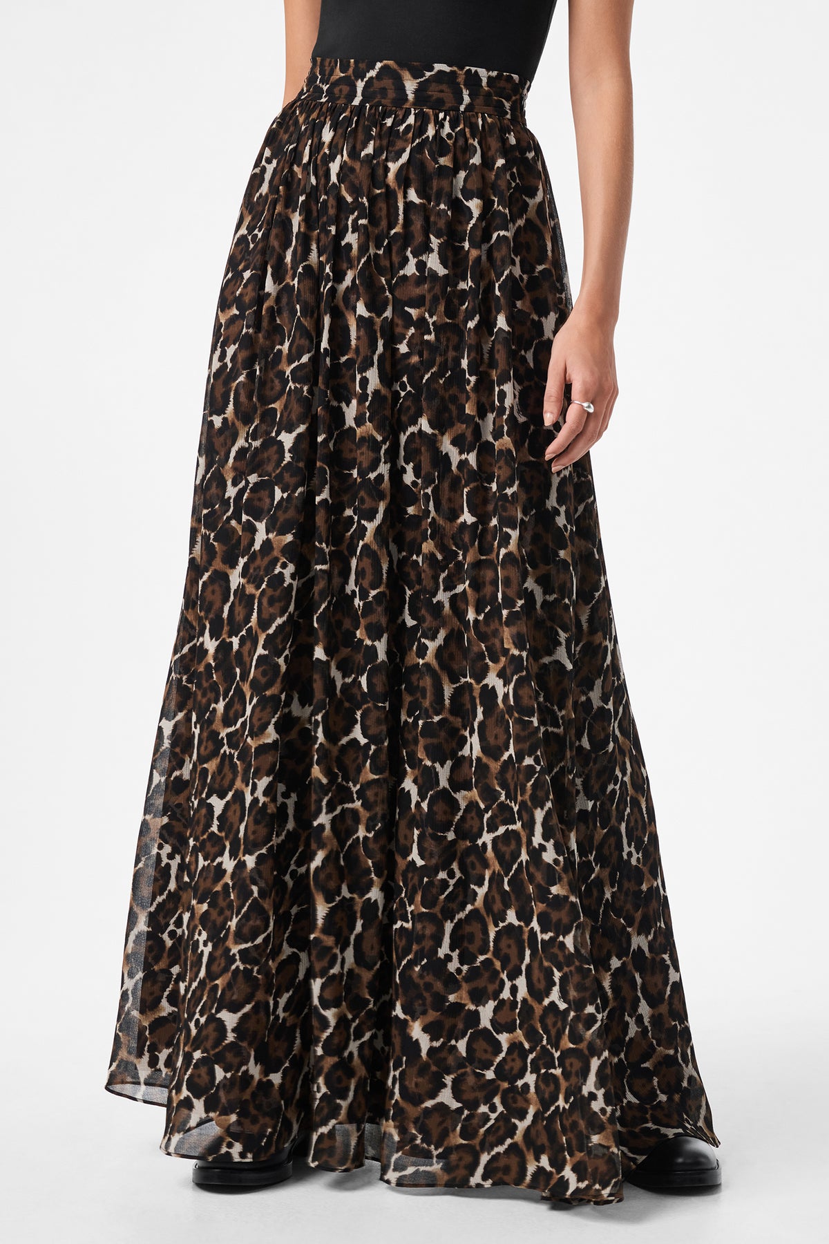 Only the lower half of the body is visible, showing a person wearing the Bersha Skirtâ€”a high-waisted, floor-length, flowy brown and black leopard print skirtâ€”paired with a tucked-in black top.