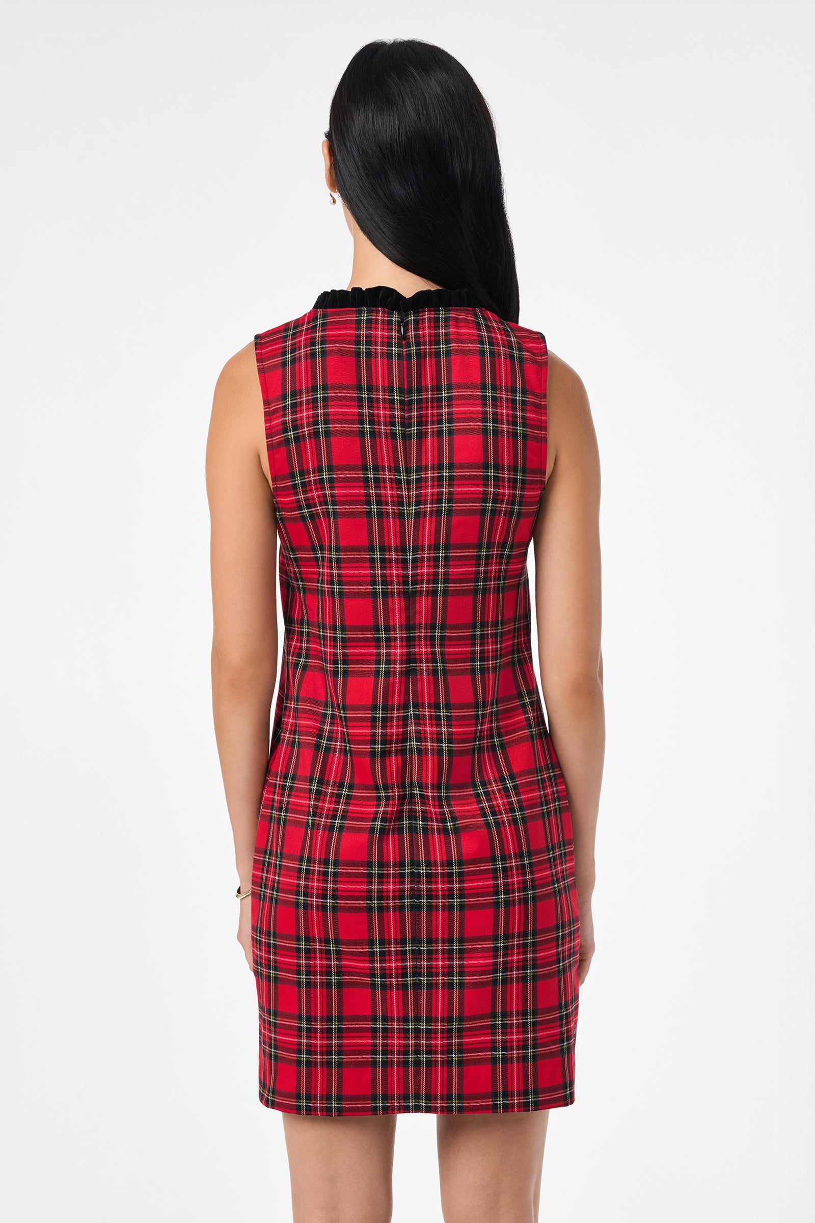 A woman with long black hair is seen from behind in a sleeveless, fitted Revah Dress featuring red plaid, set against a plain white background.