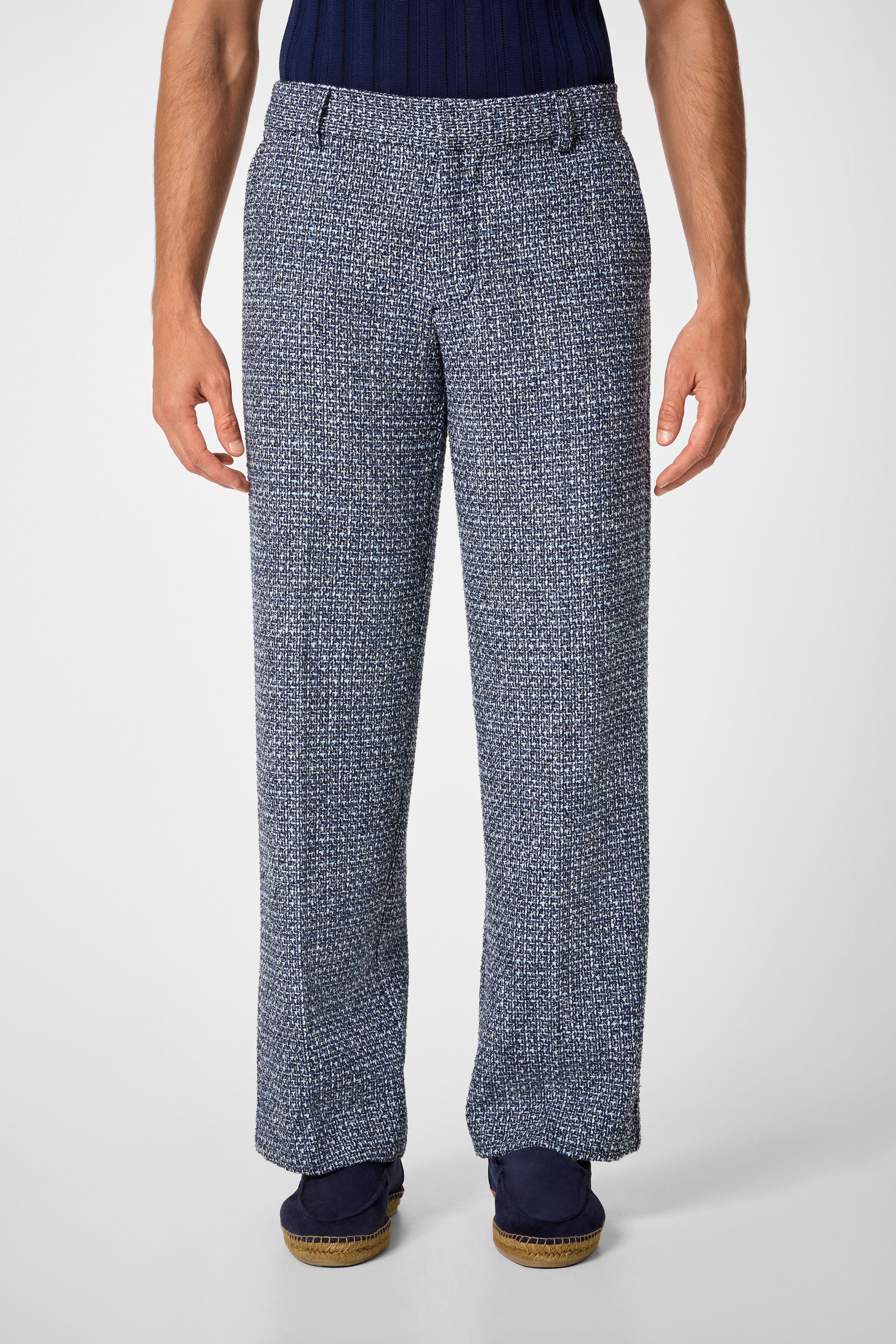 A person wearing the Buckingham Trouser in blue and white, paired with a dark blue top and navy shoes, stands against a plain light background.