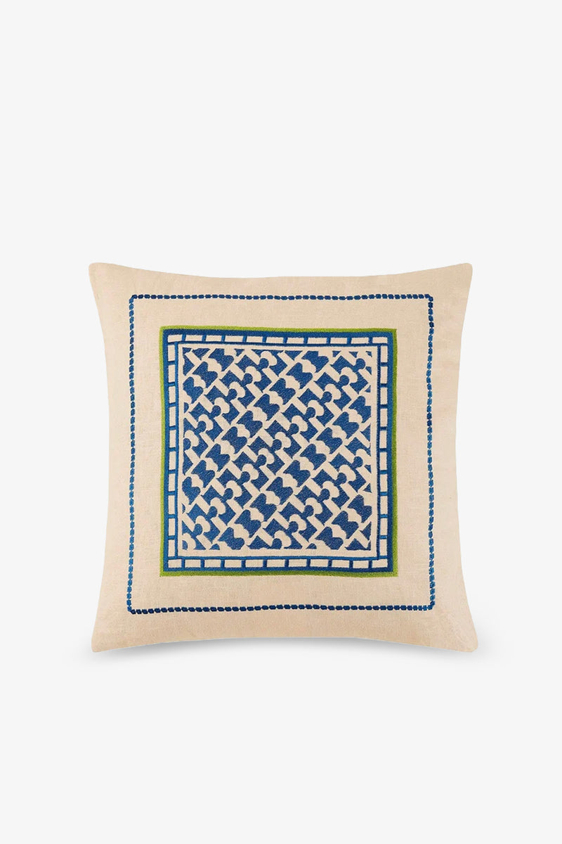 The Montecito Embroidered Square Pillow features a beige base with blue and green geometric embroidery at the center, accented by a decorative border for a modern, artistic touch.