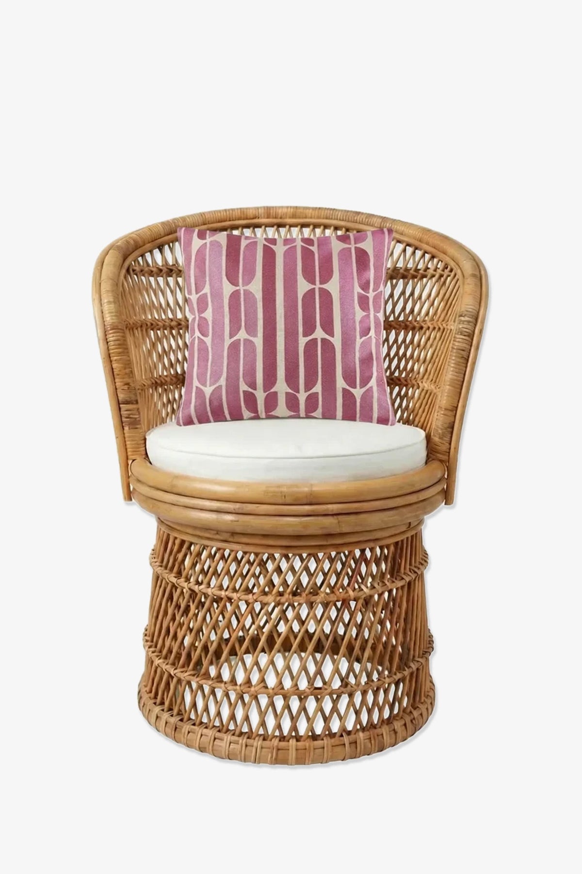 A rattan chair with a round base, curved back, and white cushion features the Palmdale Embroidered Square Pillow in ombré pink resting against the back on a plain white background.