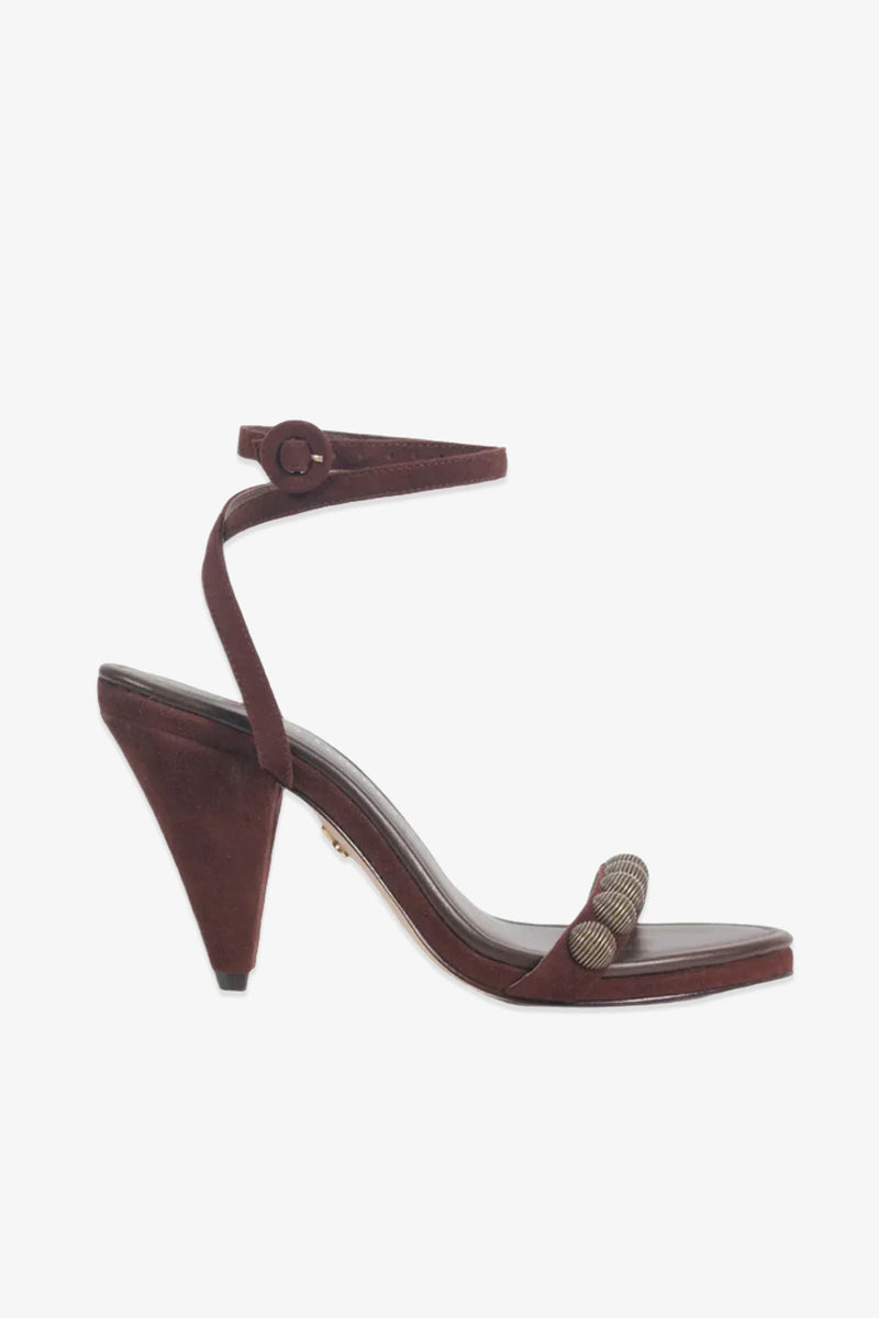 A single Paula Torres Espanha Sandal in burgundy is displayed on a white background, showcasing its striking architectural triangle heel, ankle strap with button closure, open toe, and textured metallic detail on the front strap. Designed for added comfort, this high-heeled sandal features a cushioned insole.