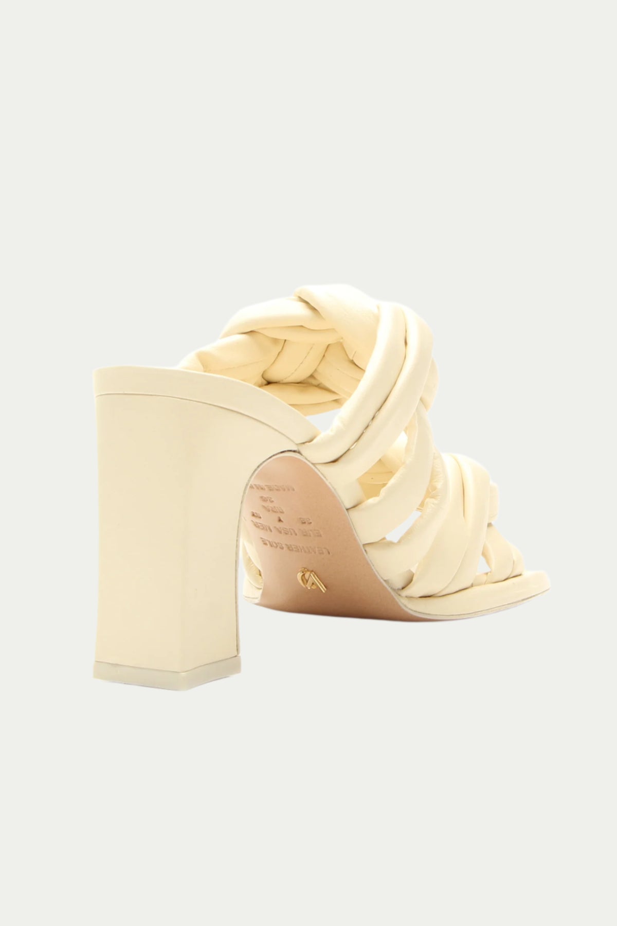 The Montpellier Leather Knot Heel Sandal in white features thick, braided straps and a cream-colored block heel, shown from the back right angle against a plain light background.