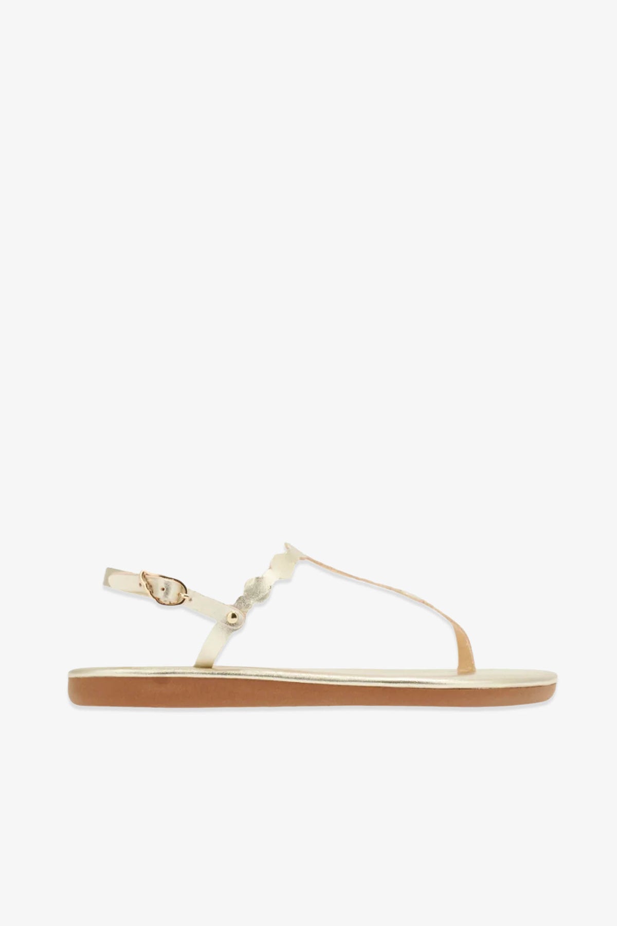 Ancient Greek Sandals Velos: A beige flat leather sandal featuring a thin ankle strap with a gold buckle and minimal straps across the foot, inspired by ancient Greek sandal design, displayed in side profile on a white background.
