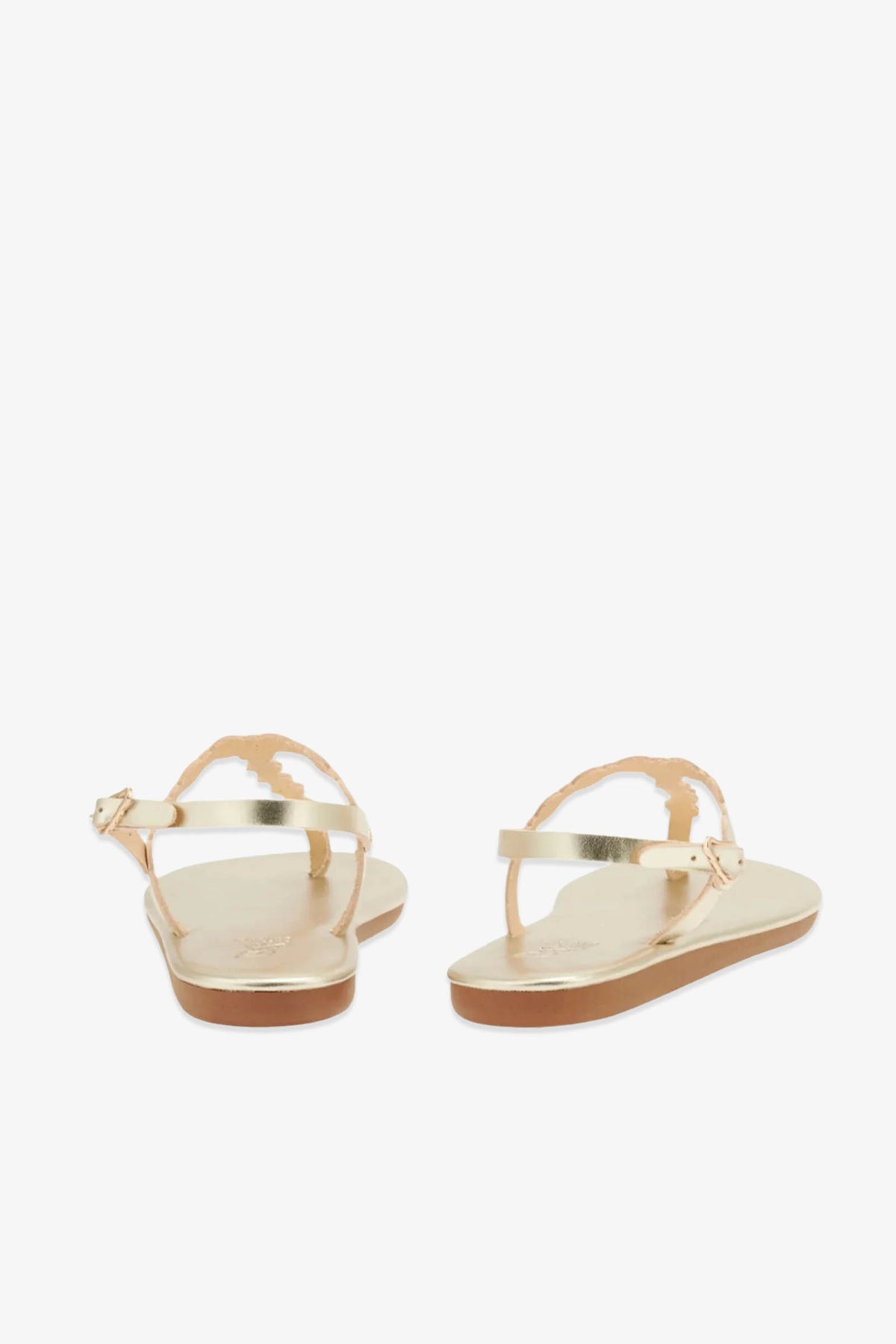 The Ancient Greek Sandals Velos are gold leather sandals featuring ankle straps and scalloped edges, inspired by ancient Greek designs; they are shown from the back against a white background.