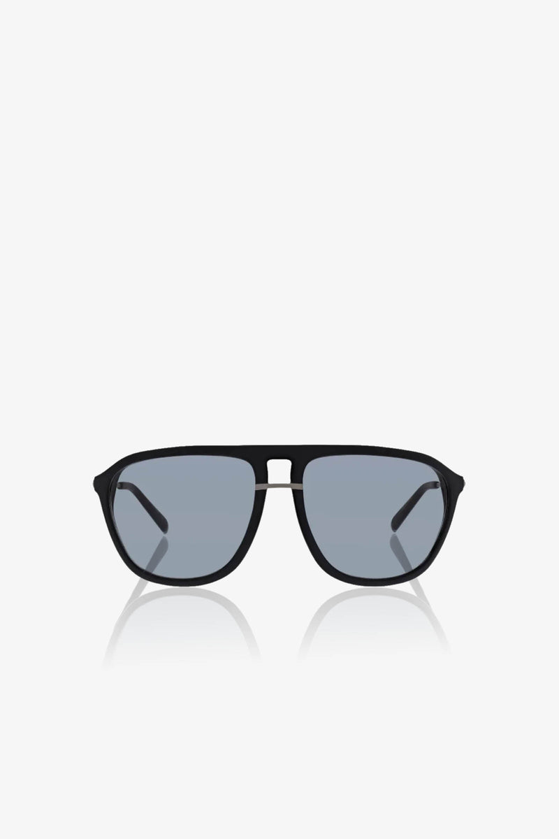 The Stern Sunglass features black aviator frames with oversized blue tinted lenses, showcased against a white background. Combining style and comfort, these sunglasses provide reliable UV protection.