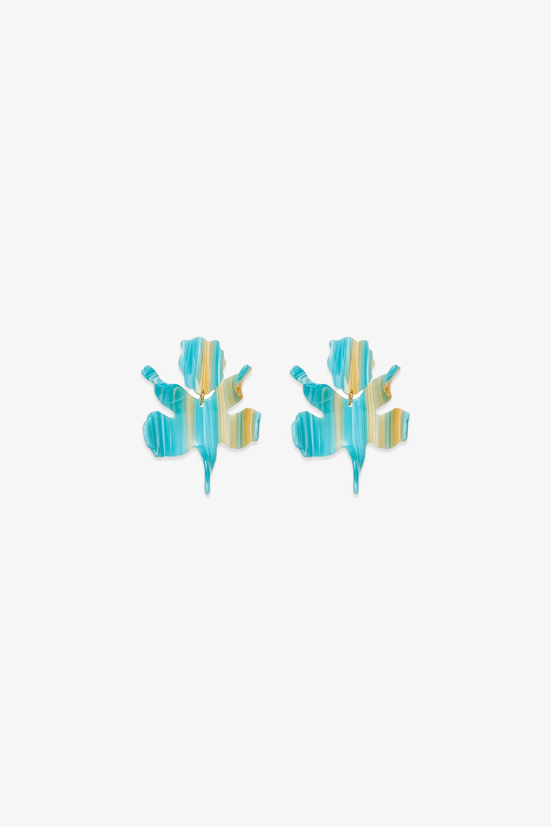 The Paper Lily Earrings are a pair of leaf-shaped statement earrings crafted from hand-swirled acetate with blue, teal, and yellow stripes, shown against a plain white background.