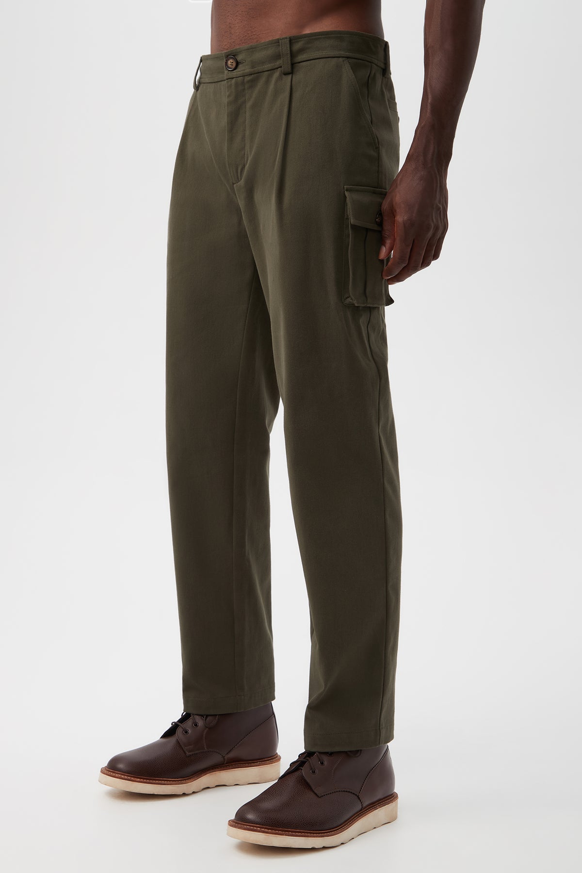 A person in Lincoln Heights Cargo Trouser - Brushed Twill with side pockets and brown lace-up shoes stands against a plain white background.