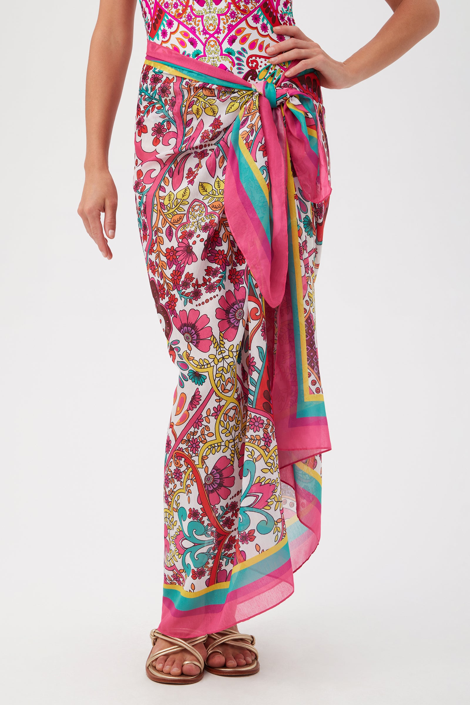 She wears the Hawaiian Garden Pareo Swim Cover-Up in MULTI, tied at the waist over a matching swimsuit, and pairs it with strappy flat sandals for a stylish resort-ready look.