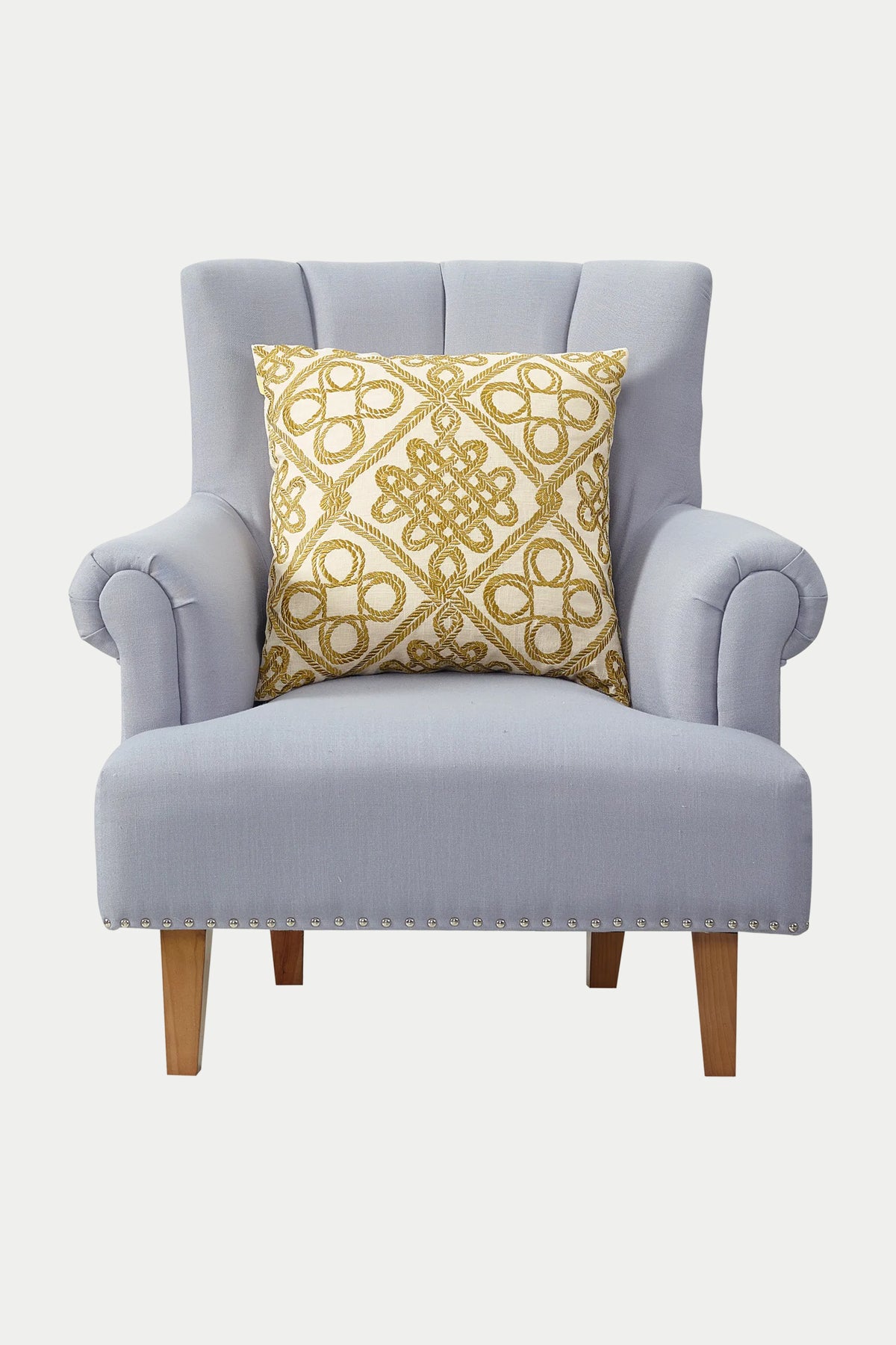 A light gray upholstered armchair with wooden legs and silver nailhead trim features the Costa Mesa Embroidered Euro Throw Pillow in gold placed on the seat.