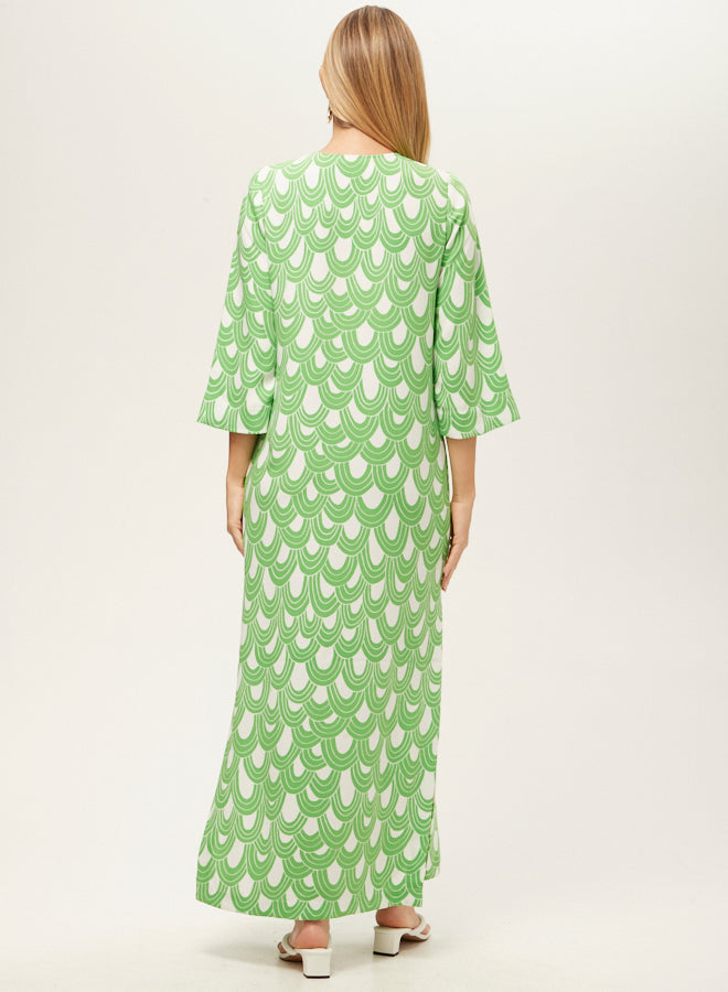 Woman wearing a green dress with white pattern on a white background