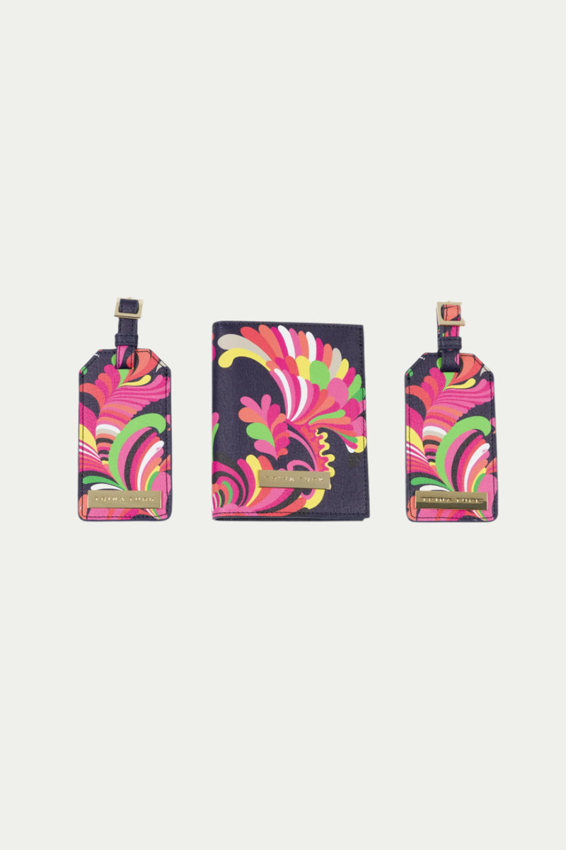 The Passport Tag Set - Palms Paradise includes a multi-colored passport holder and two luggage tags with abstract swirl patterns on a dark background, each featuring a gold nameplate.