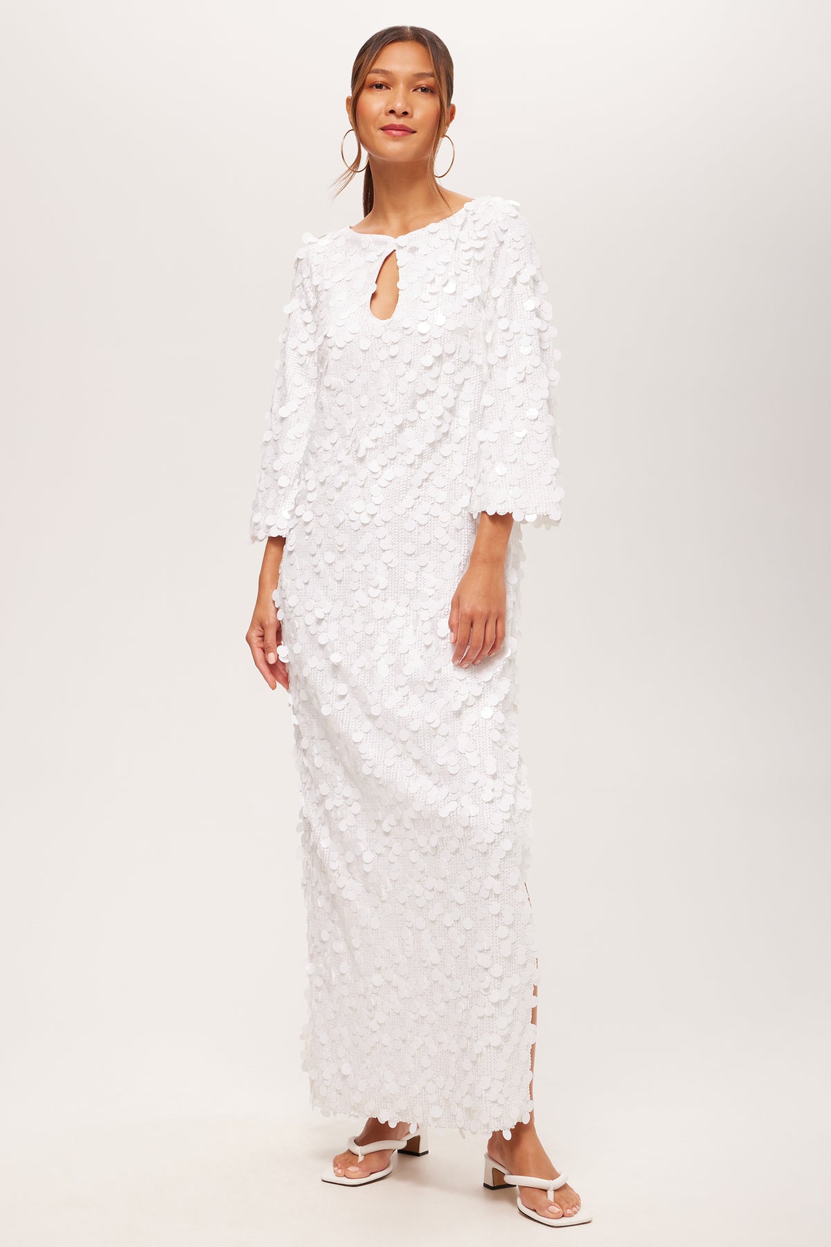 A woman models the Singles 3/4-Sleeve Keyhole Maxi Dress in white, styled with hoop earrings and white sandals, standing against a plain background.