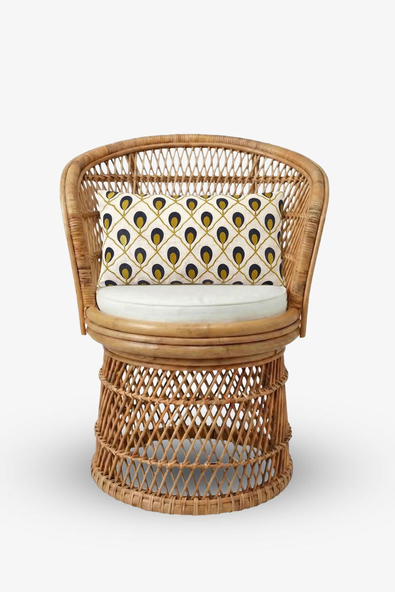 A round wicker chair with an intricate woven design, light cushion, and the Roseville Embroidered Lumbar Pillow featuring a yellow, black, and gray peacock feather pattern, set against a plain white background.