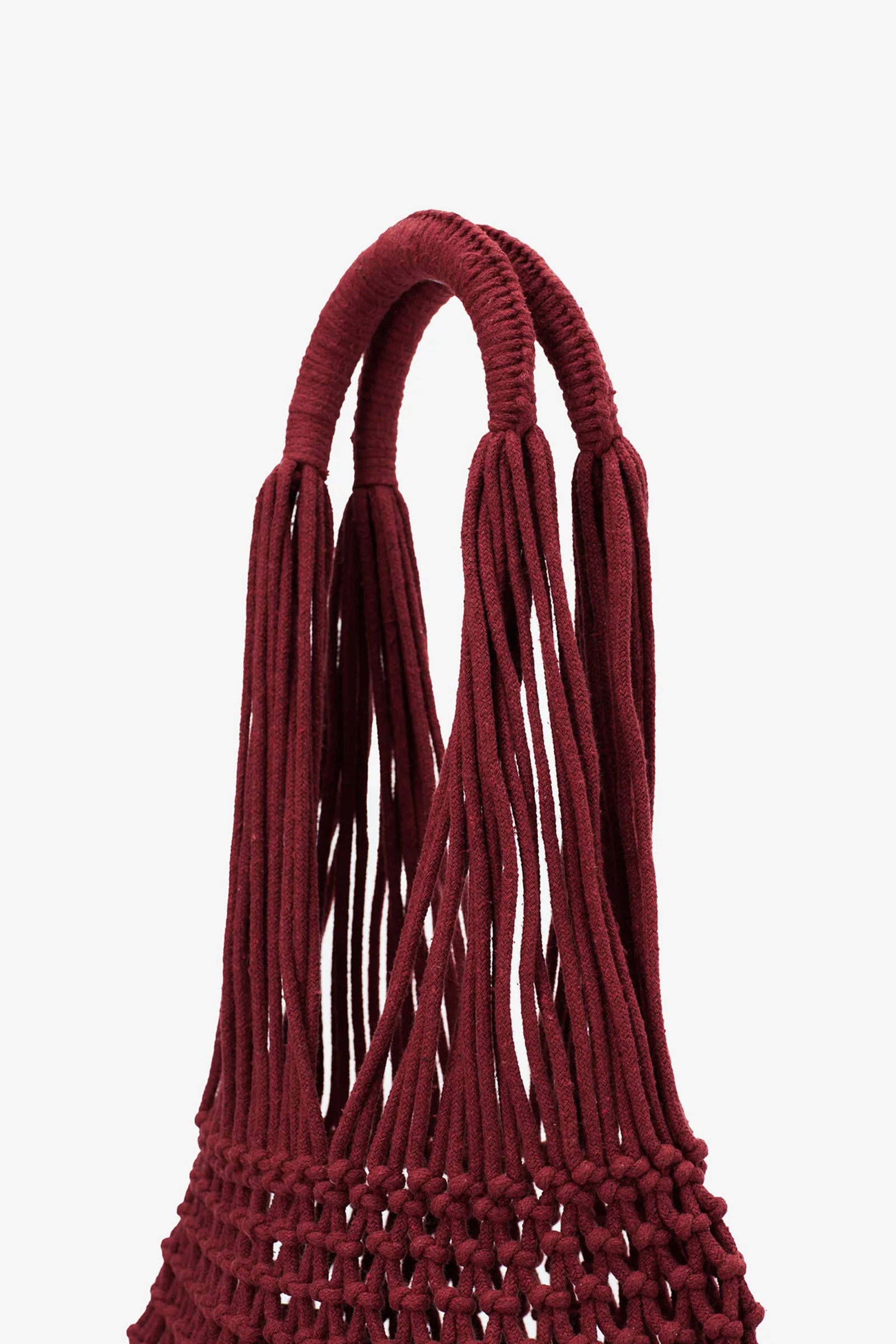 Close-up of the Nannacay Alessandra Woven Bag’s burgundy handle, crafted from multiple thick, twisted cords, highlighting the intricate knotting and weaving details against a plain white background.