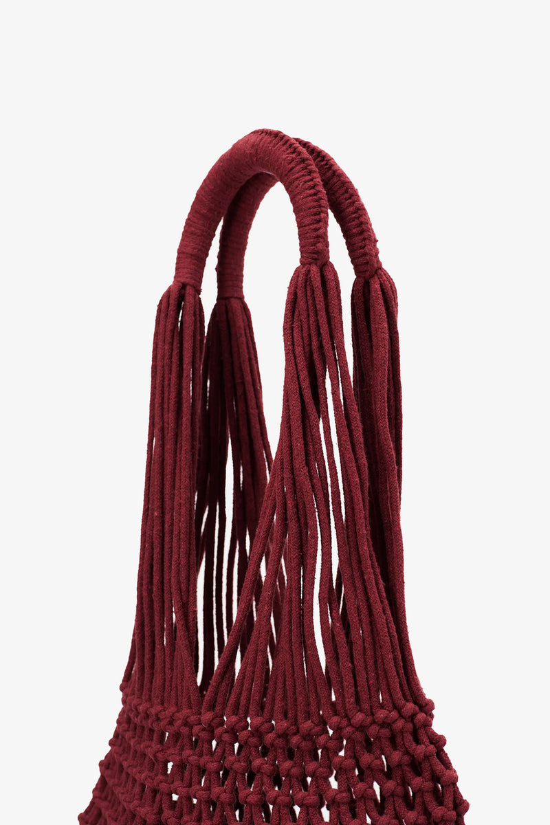 Close-up of the Nannacay Alessandra Woven Bag’s burgundy handle, crafted from multiple thick, twisted cords, highlighting the intricate knotting and weaving details against a plain white background.