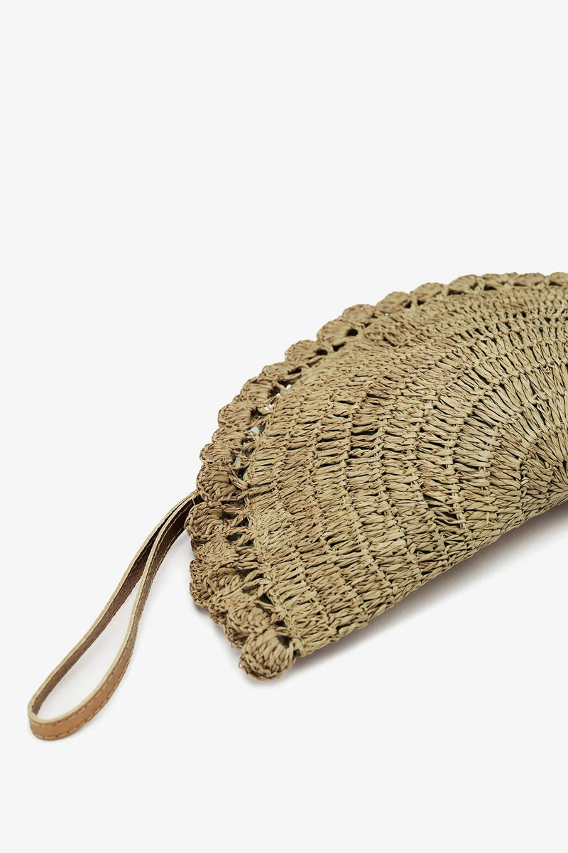 A close-up of the Nannacay Malu Clutch, showcasing its woven straw construction, scalloped edge, and leather wrist strap against a plain white background.