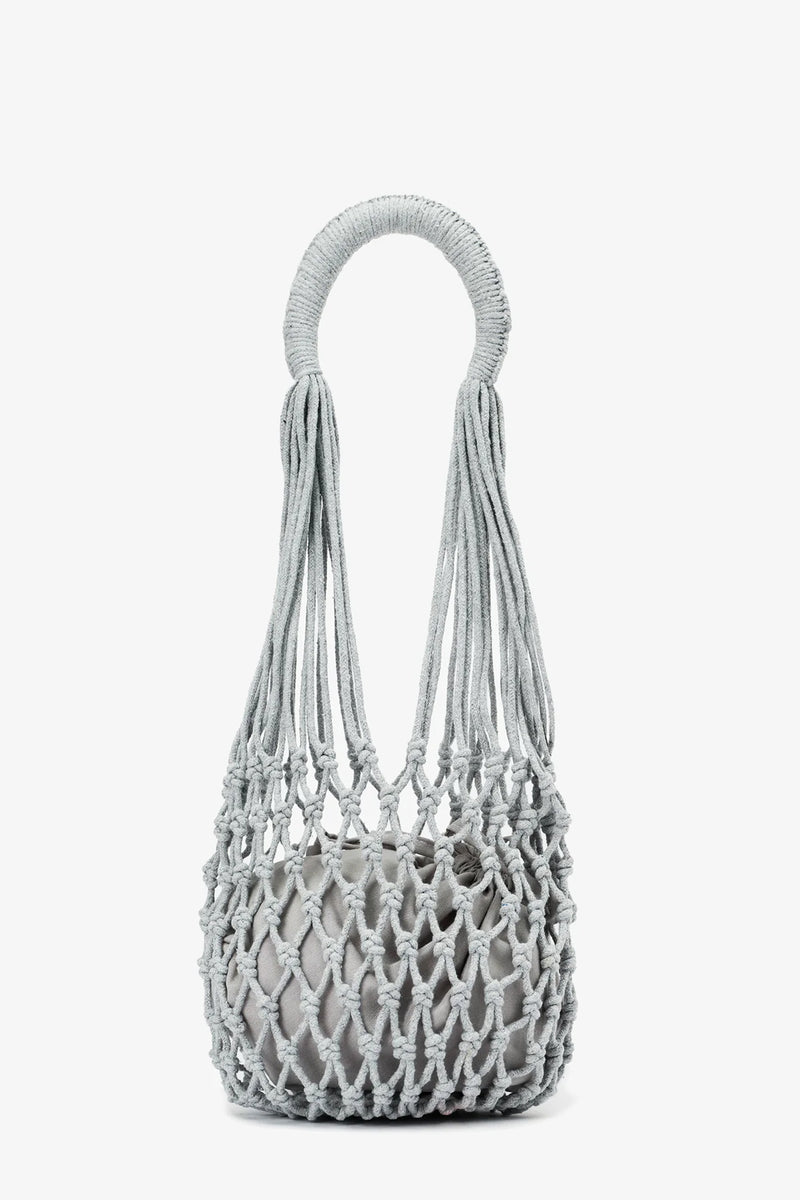 Introducing the Nannacay Kim Woven Bag—a light gray, knotted rope handbag featuring a circular handle and an open, net-like design with a compact inner pouch.