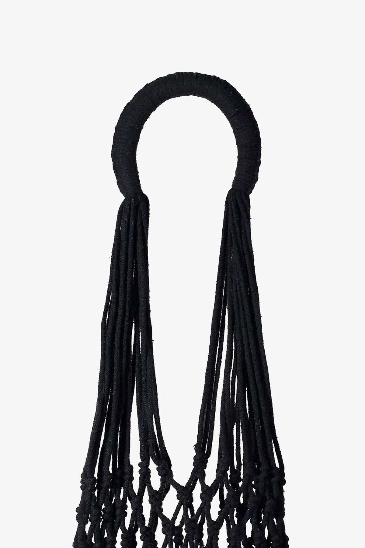 The Nannacay Kim Woven Bag features a black circular handle wrapped in fabric, with long, loose black cords hanging down to form the upper section of the intricately knotted bag, all set against a white background.