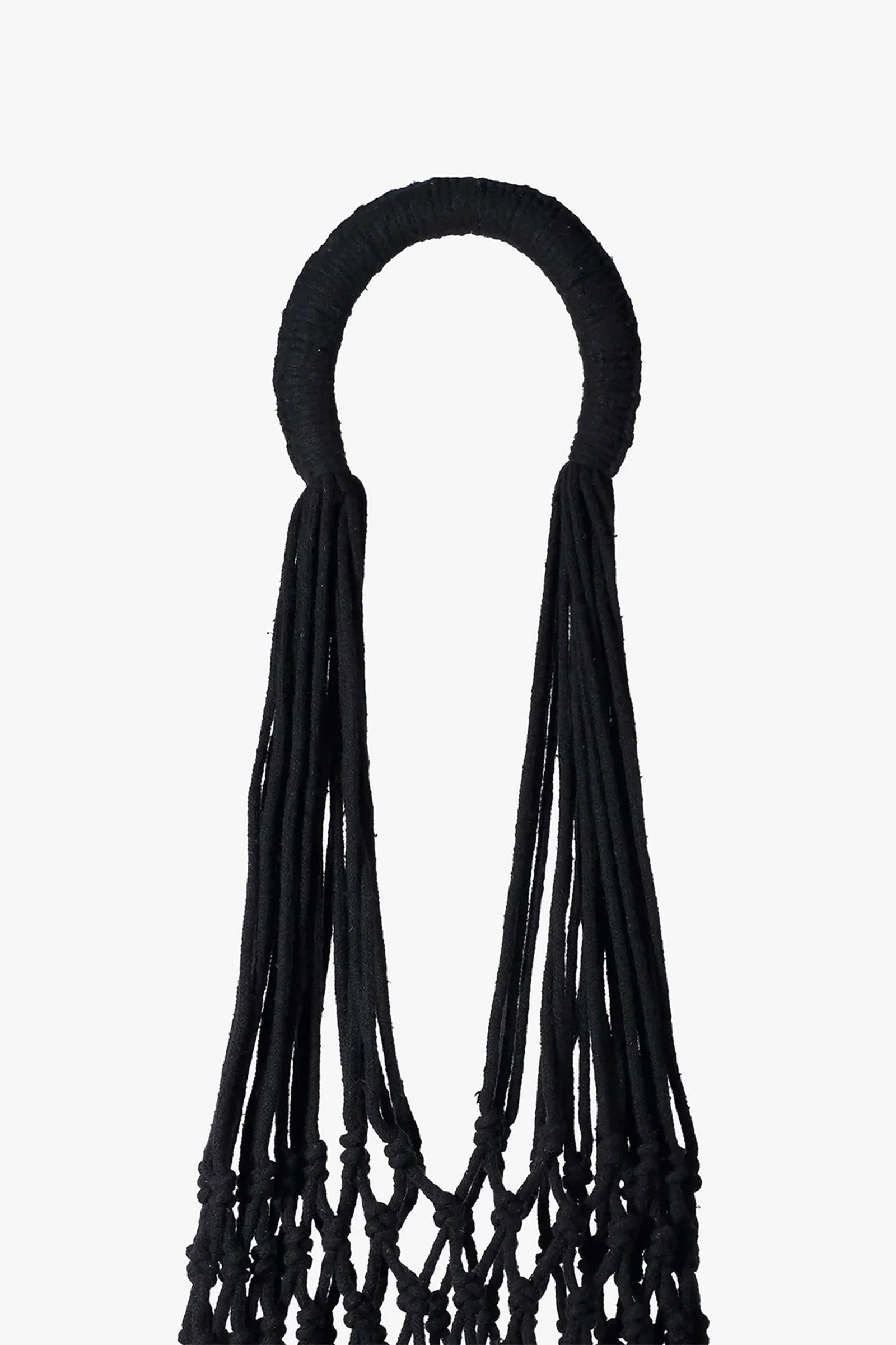 The Nannacay Kim Woven Bag features a black circular handle wrapped in fabric, with long, loose black cords hanging down to form the upper section of the intricately knotted bag, all set against a white background.