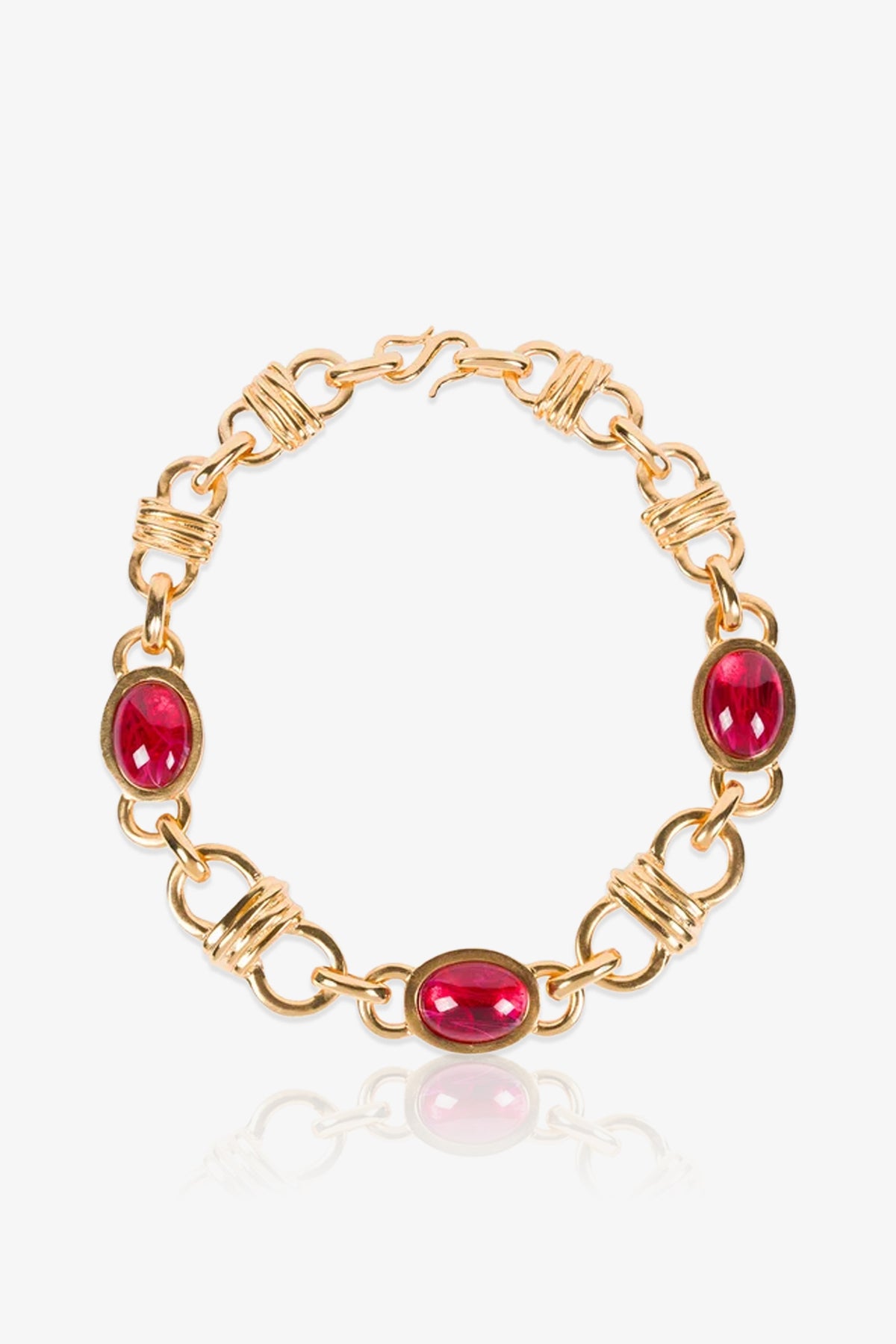 Ruby Oval Link Necklace, featuring oval red gemstones connected by gold links wrapped with wire detailing, displayed on a white background with a slight reflection below.