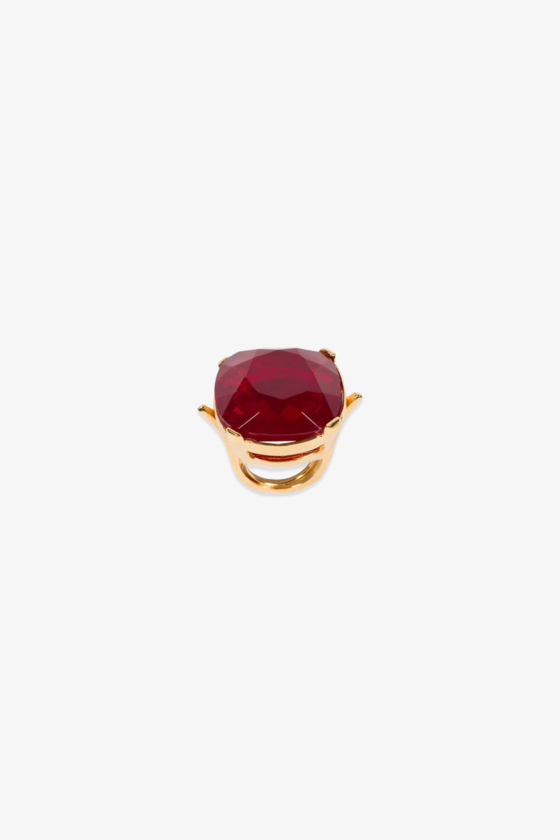 A Ruby Faceted Cocktail Ring featuring a large, oval-shaped red gemstone set in the center, displayed on a plain white background.