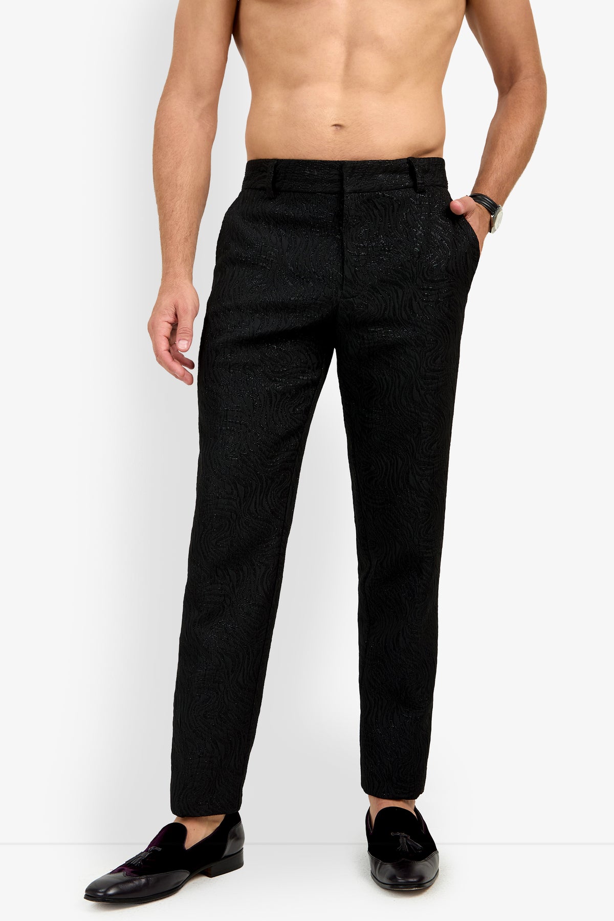 Shirtless man wearing Clyde Slim Trouser in black with black loafers and a watch, standing against a plain white background.