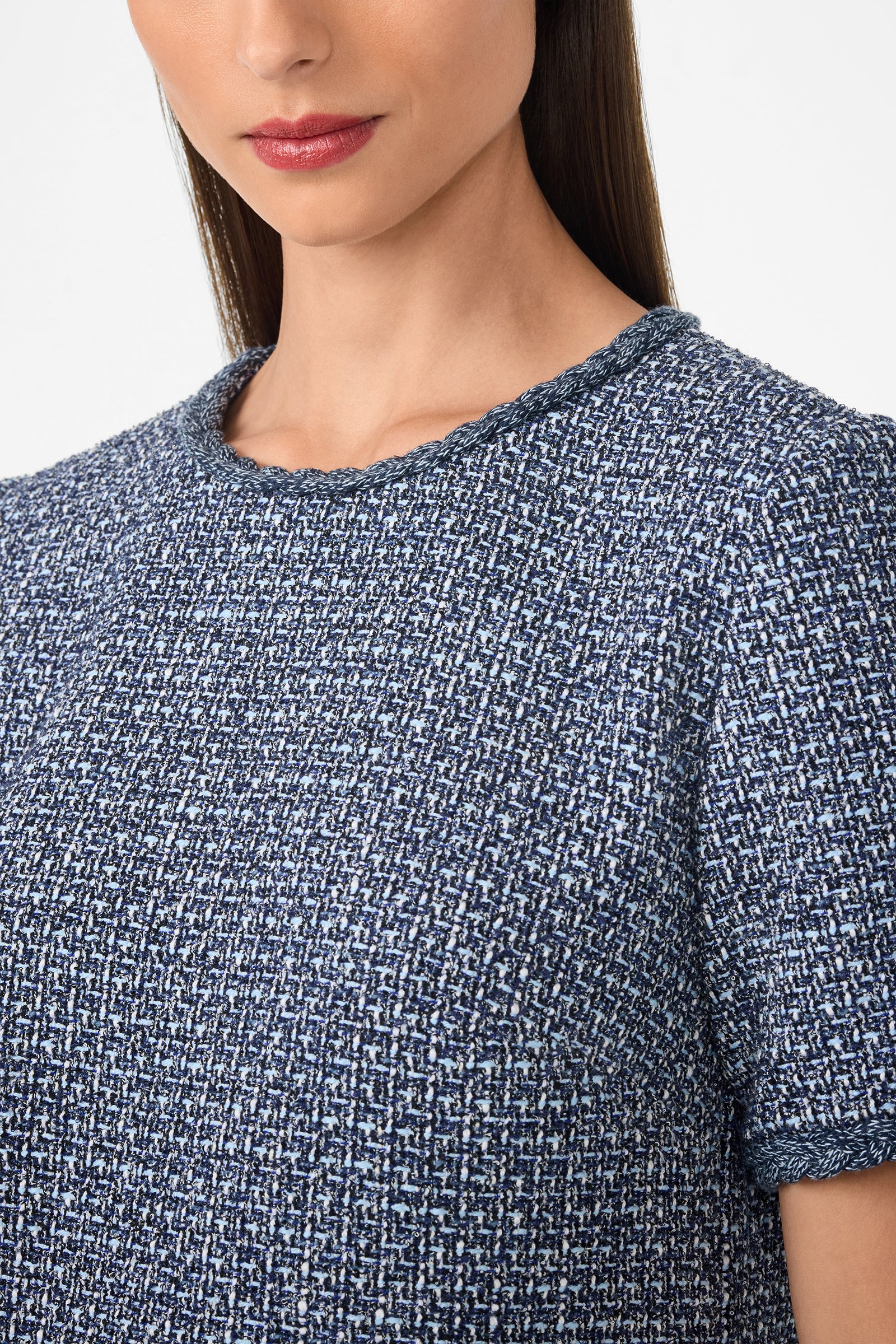 A woman wears the Akara Dress, a blue-and-white textured tweed top with short sleeves and a round neckline, shown from shoulders to above the waist against a plain background.