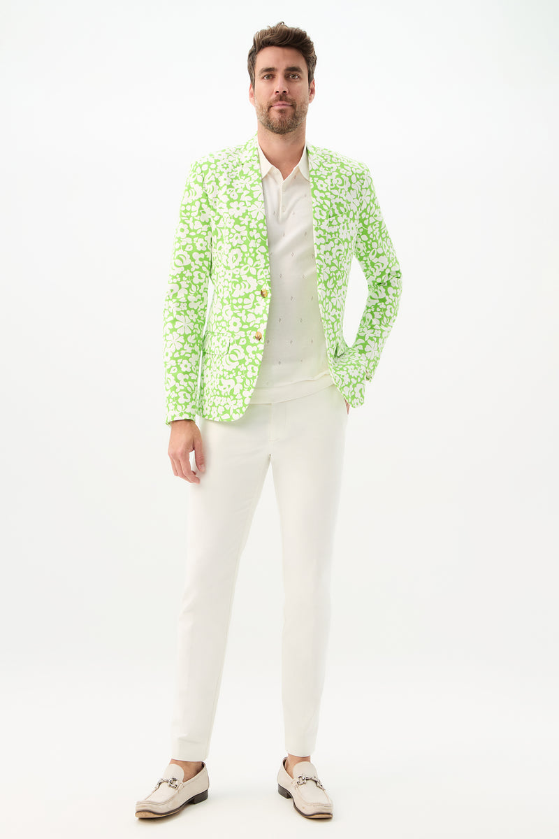 A man with short brown hair and a trimmed beard stands against a white background wearing the Thurston Blazer - Poolside Gossip over a white shirt and pants, paired with white loafers.