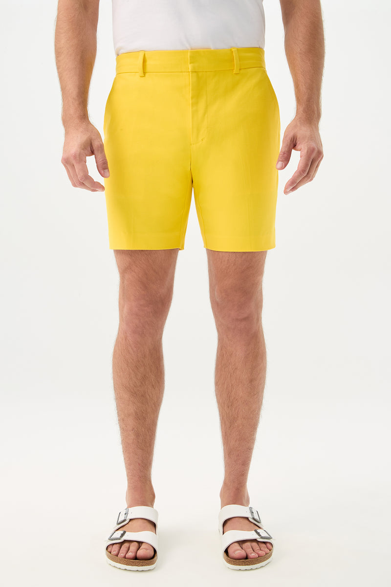 A person wearing the Cyrus Short - Sunset Stretch in Lemon stands against a plain white background. Only the lower half of the body is visible.