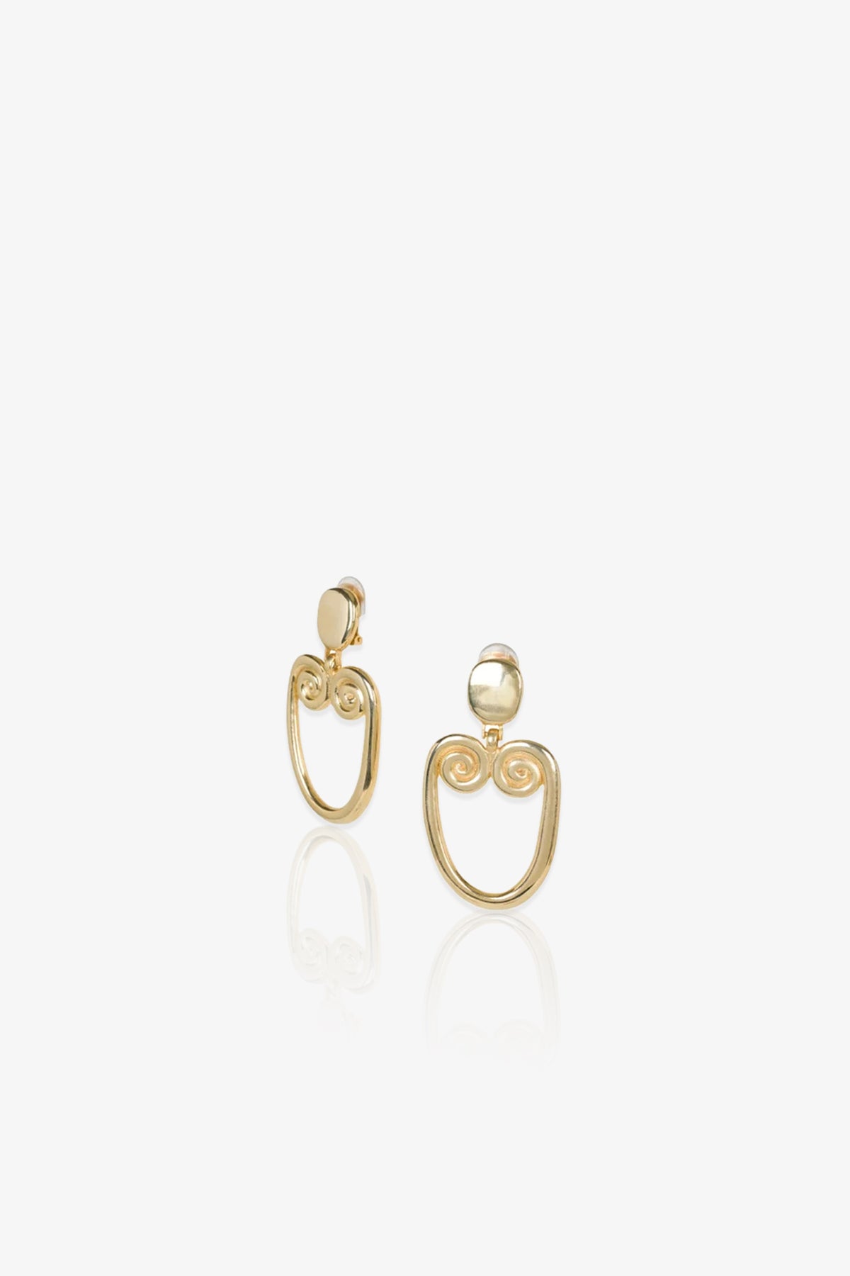 TT x KJL Gold Double Scroll Clip-On Earrings, displayed on a white background, feature round studs and open oval drops adorned with symmetrical scroll designs at the top of each oval.