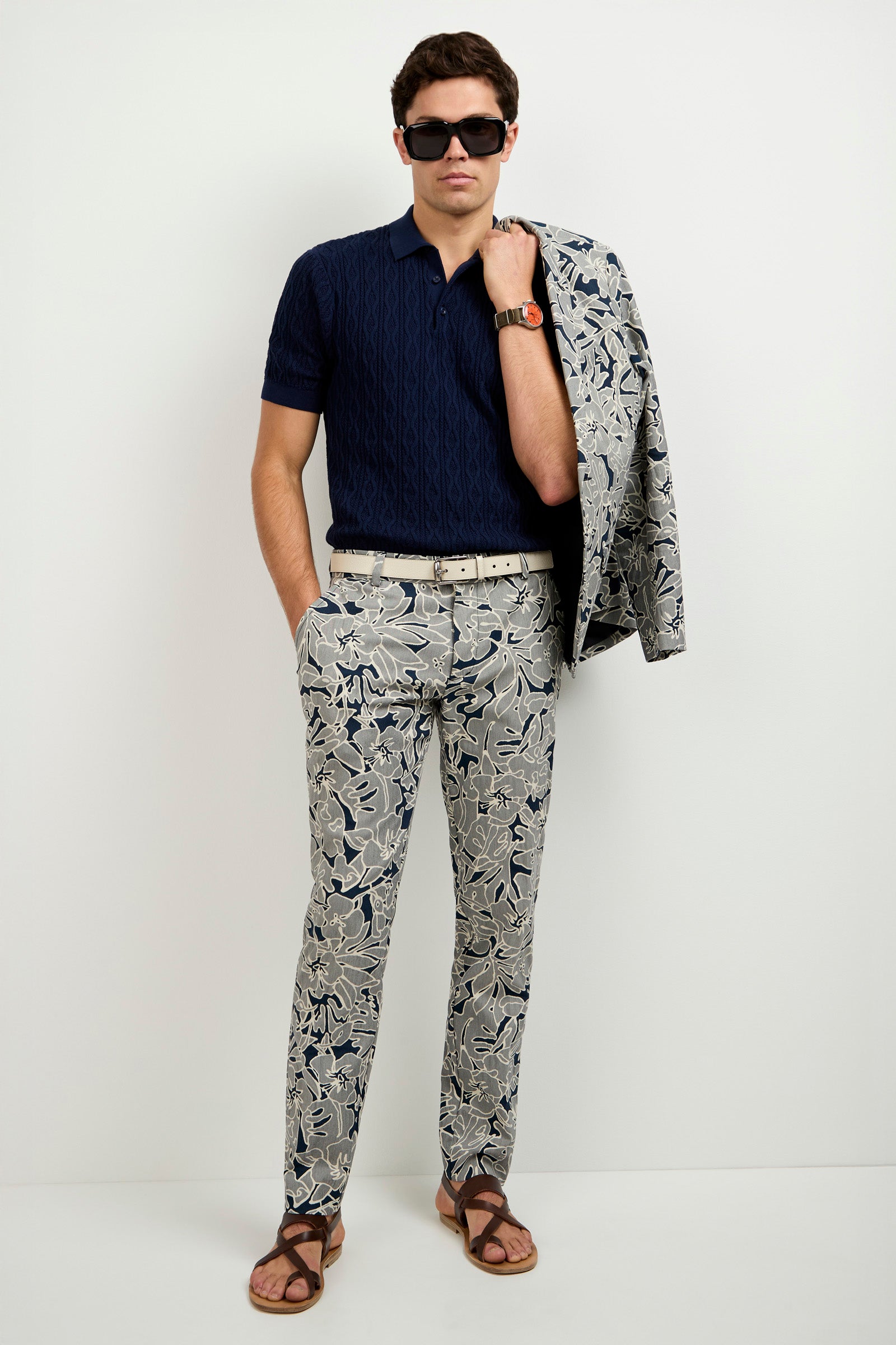 A man in a blue shirt and Artsy Floral Jacquard Clyde Slim Trousers.
