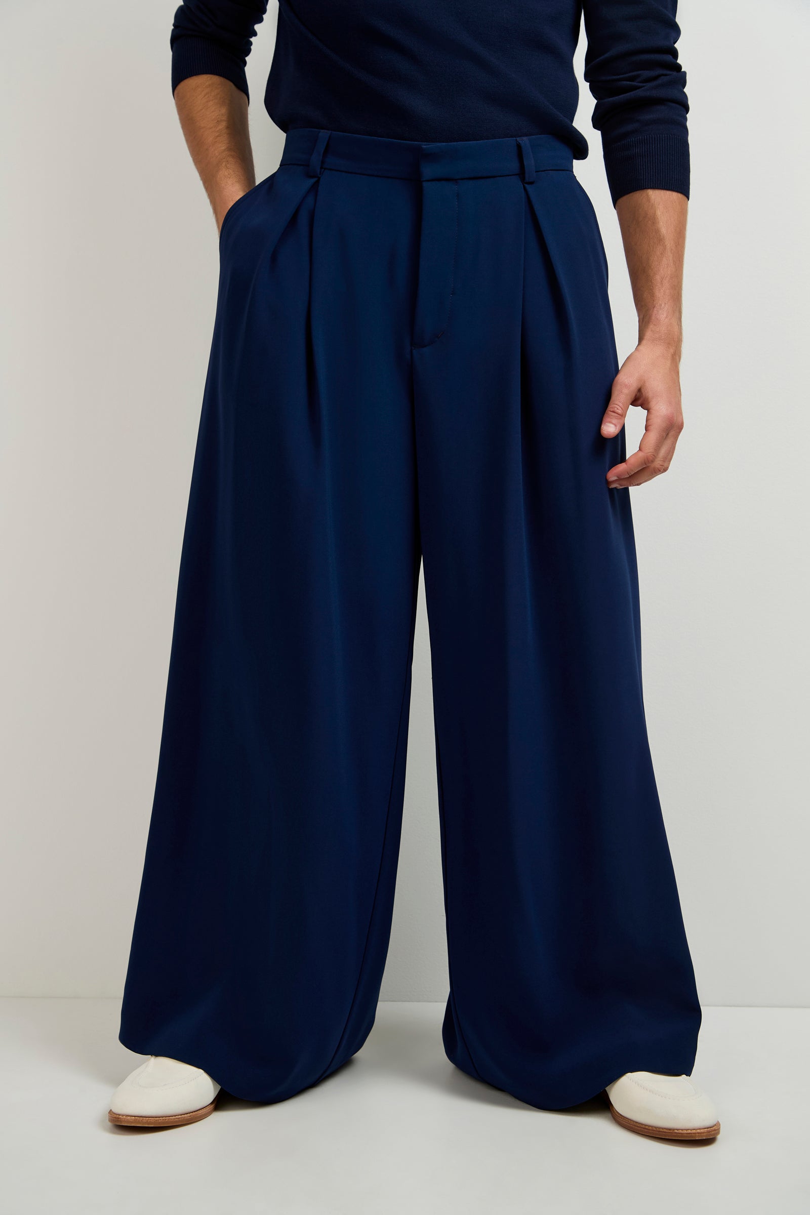 A person wearing the Clyde Wide-Leg Trouser in INK, paired with a matching long-sleeve top and white shoes, standing against a plain light background.