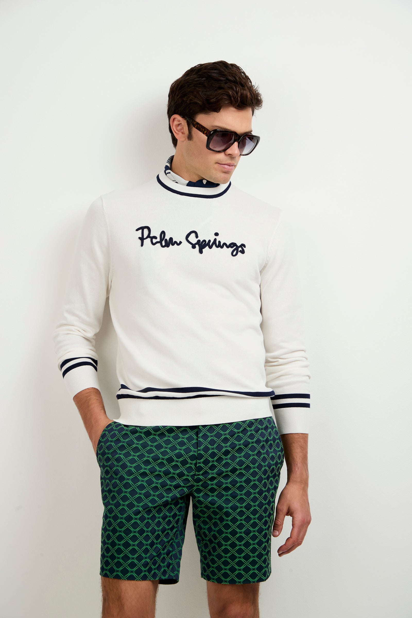 A man wearing sunglasses and the Palm Springs Crewneck Sweater.