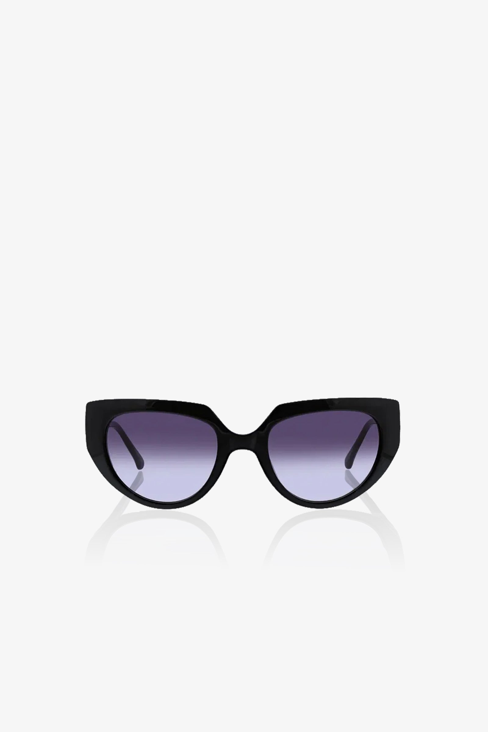 Schooner Sunglasses with a subtle cat-eye frame and dark, slightly gradient lenses are displayed against a plain white background, facing directly forward. The arms of the sunglasses extend outward and backward.