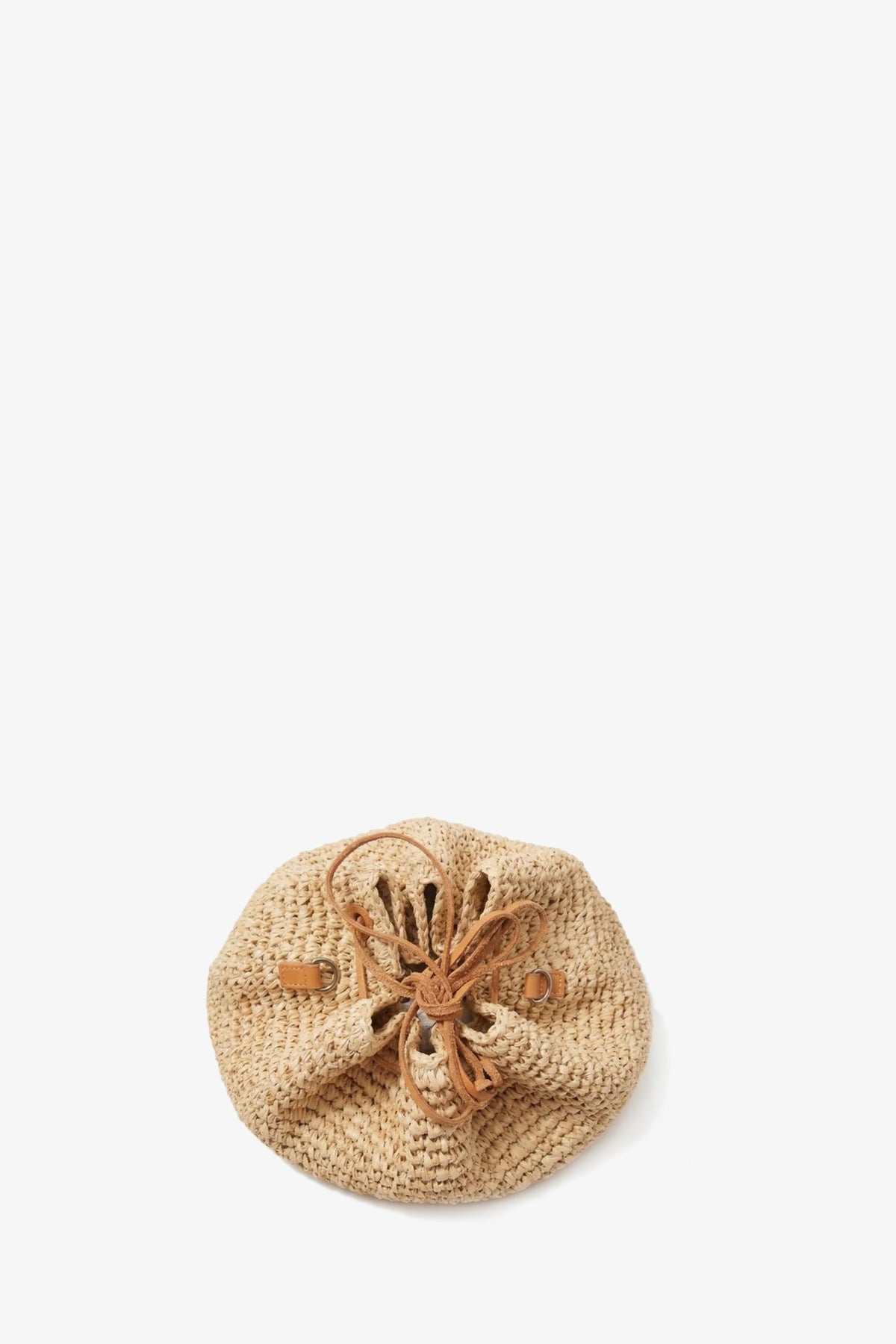 The Kayu Canary Drawstring Bag is a round, woven straw bag featuring brown leather handles and a drawstring closure, shown against a plain white background.