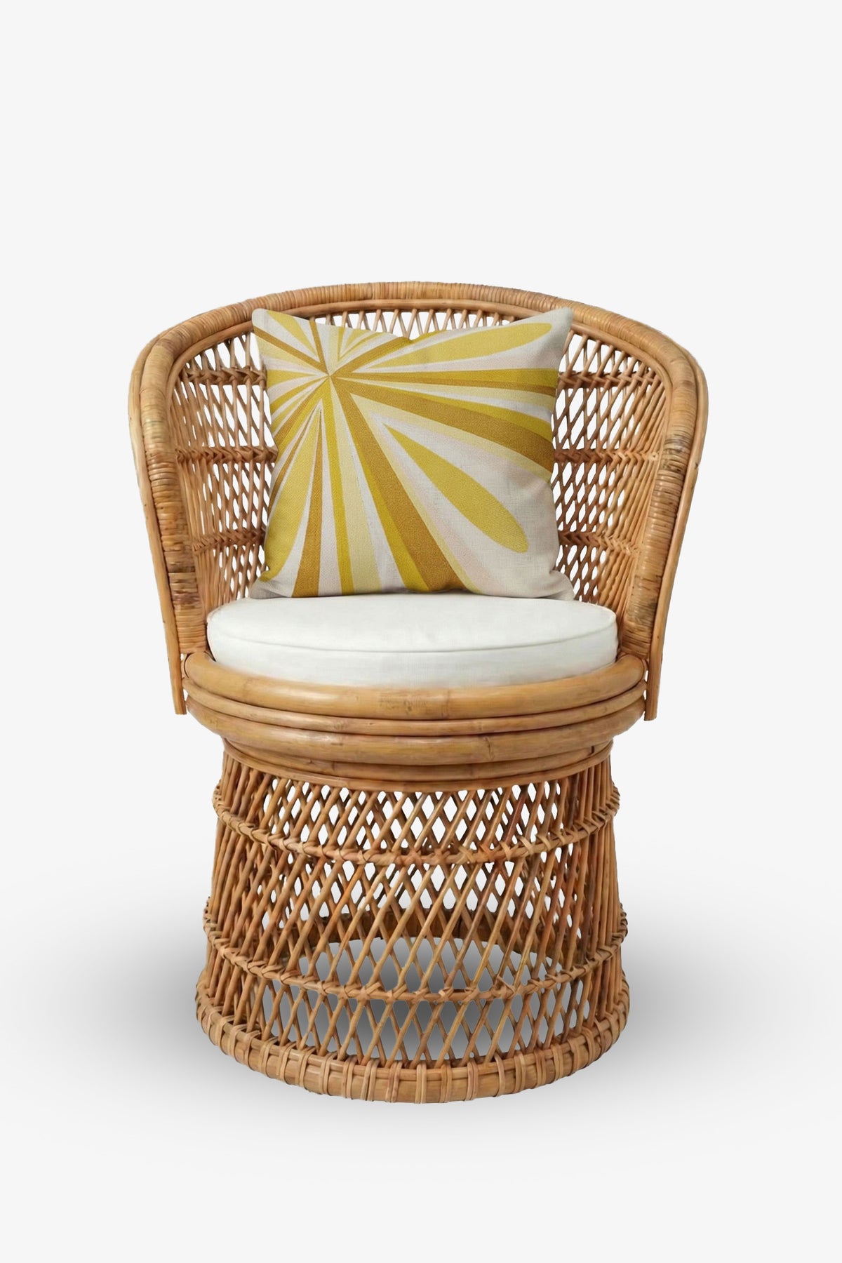 A round rattan chair with an open weave design, a white seat cushion, and the Shante Embroidered Square Pillow featuring a yellow and white sunburst pattern.