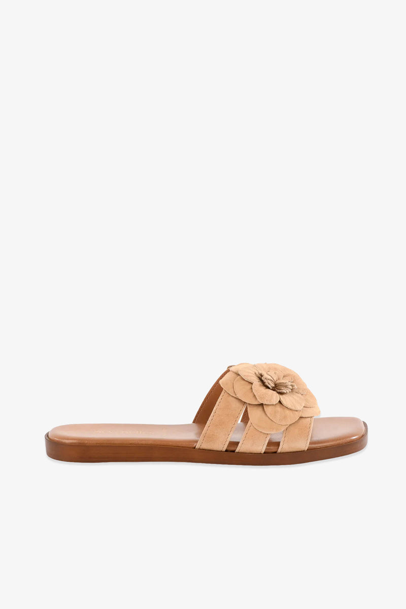 Morning Dew Slide sandal in tan, featuring a single wide strap adorned with a layered flower embellishment on top, displayed in a side view against a plain white background.
