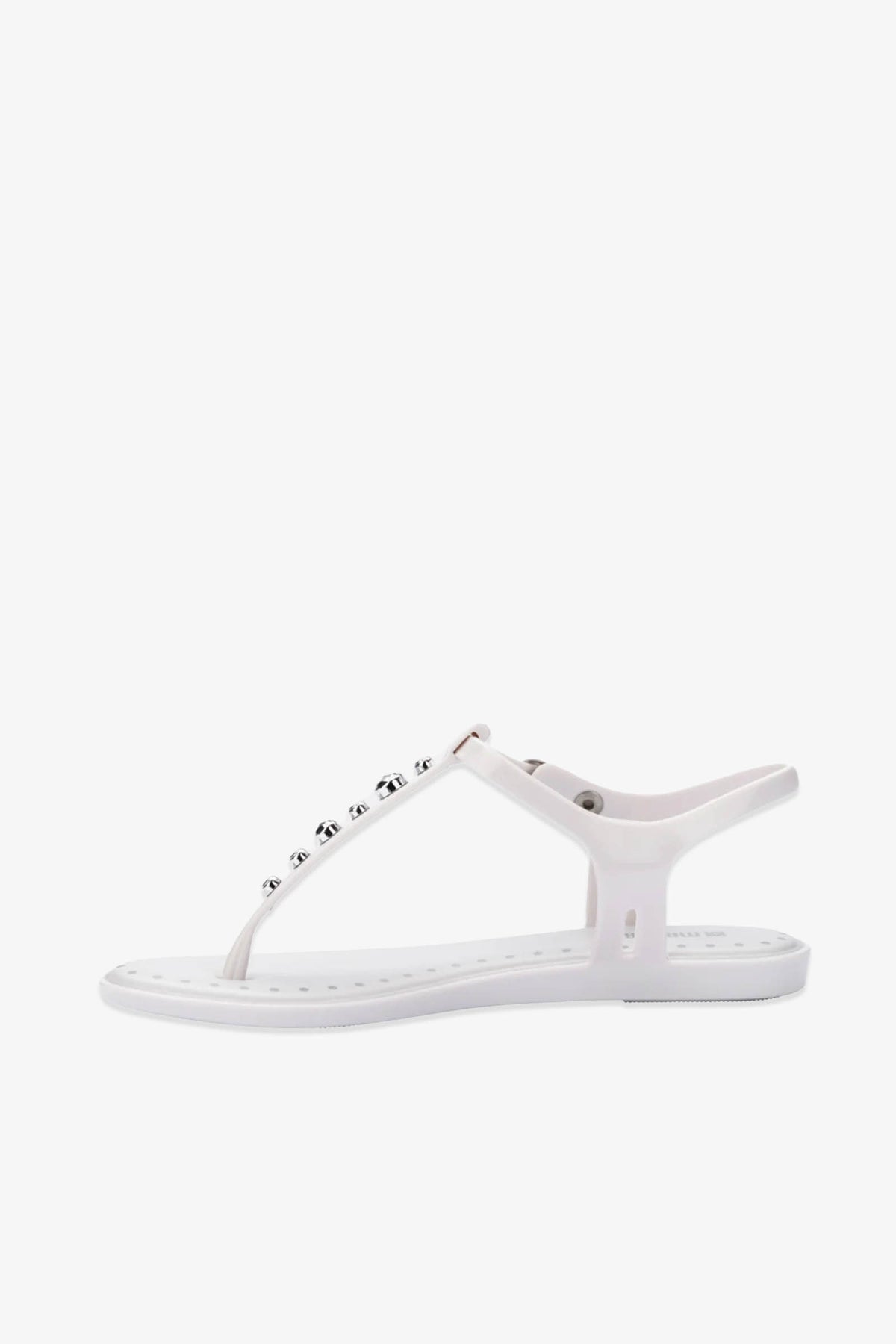 The Solar Boho Thong Sandals are white flat-soled sandals featuring a T-strap design and adorned with round metallic studs along the top strap, photographed against a plain white background.