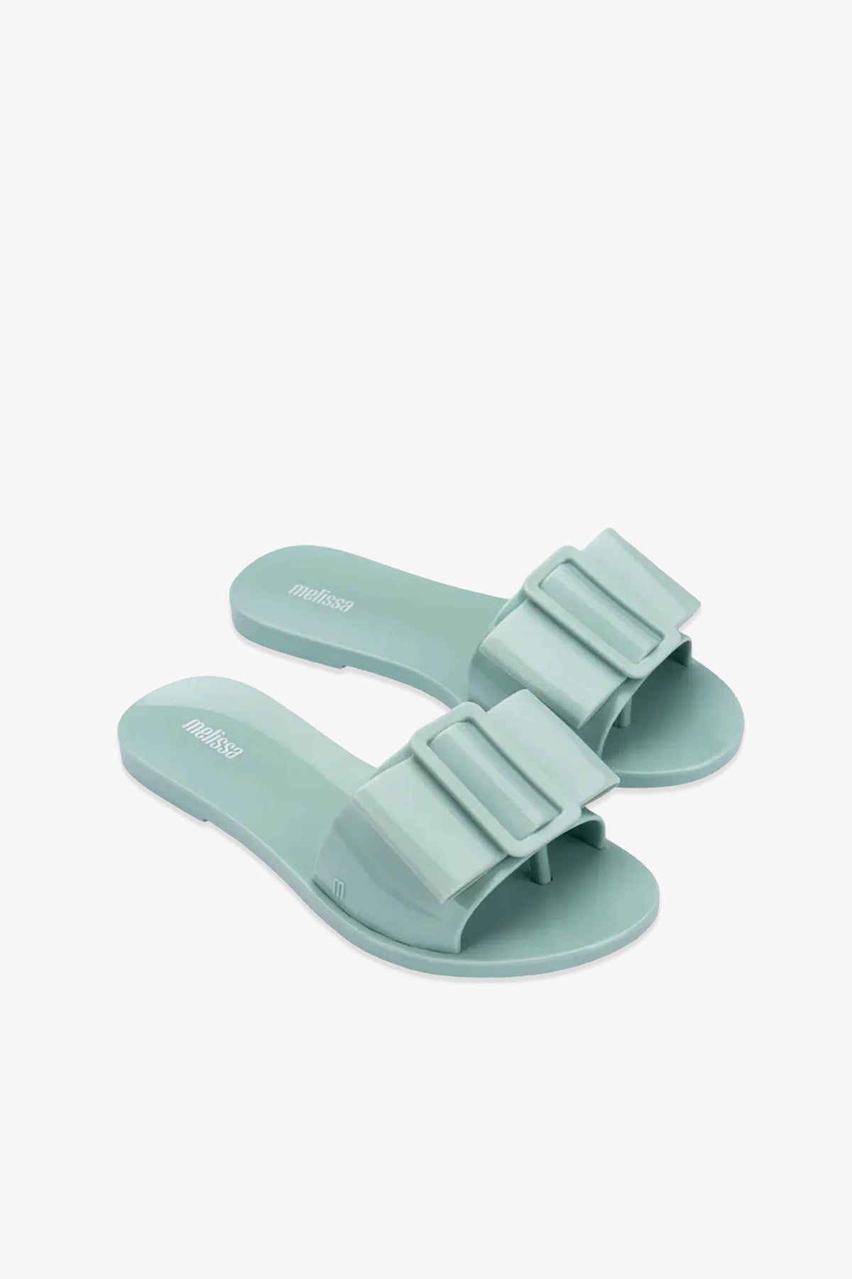 A pair of Babe Sandals in light green, featuring wide straps adorned with large matching bows, displayed on a white background.