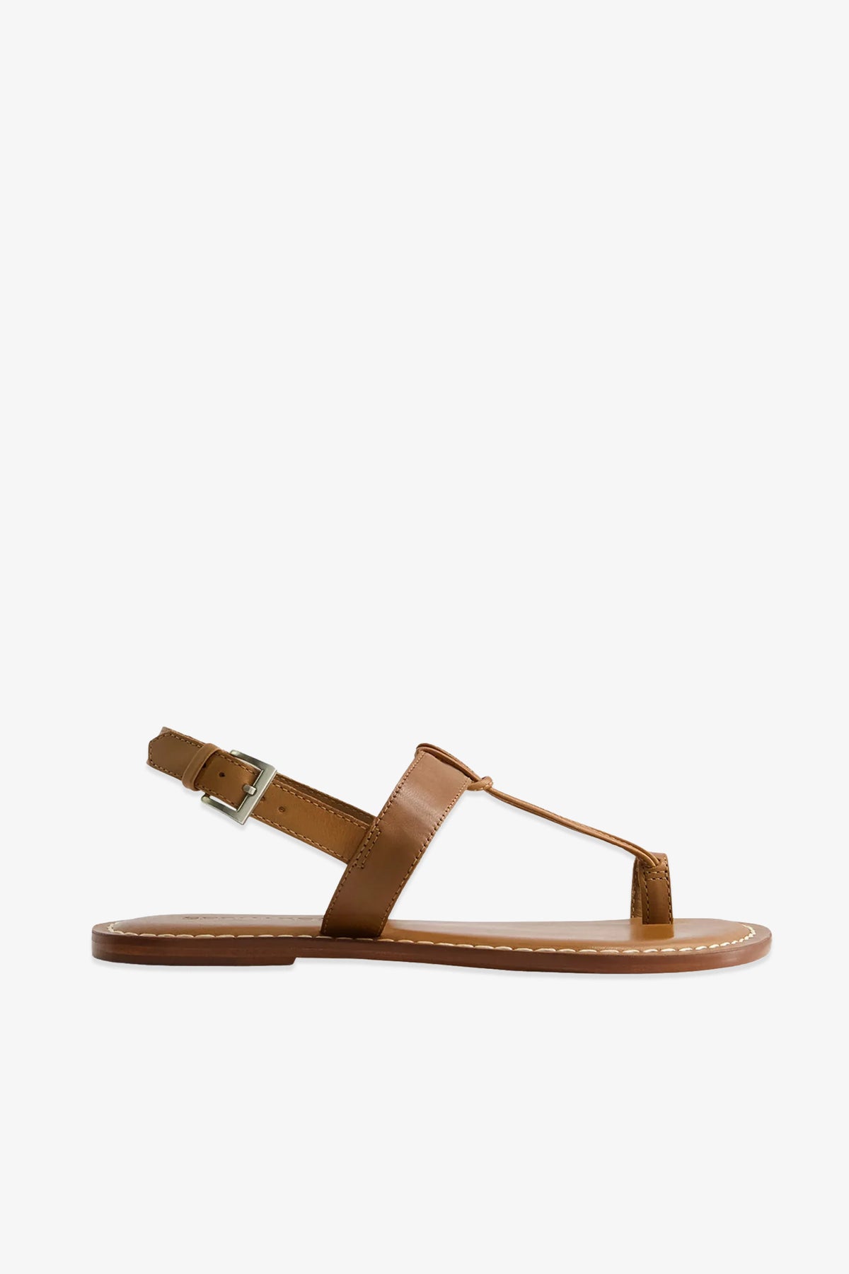 The Maverick 2 Sandal is a brown leather flat sandal featuring a T-strap design, an adjustable ankle buckle, and white stitching along the sole, displayed against a white background.