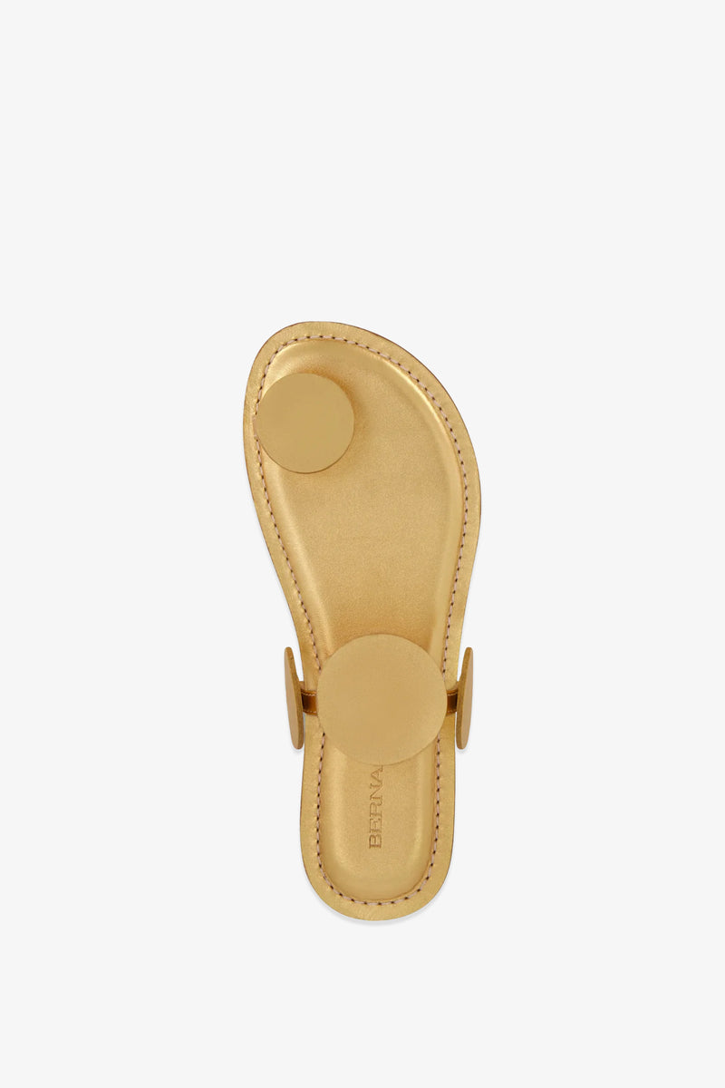 A single New Moon Sandal in tan leather, featuring circular straps and viewed from above against a white background. The sandal has “BERNA” embossed on the footbed.