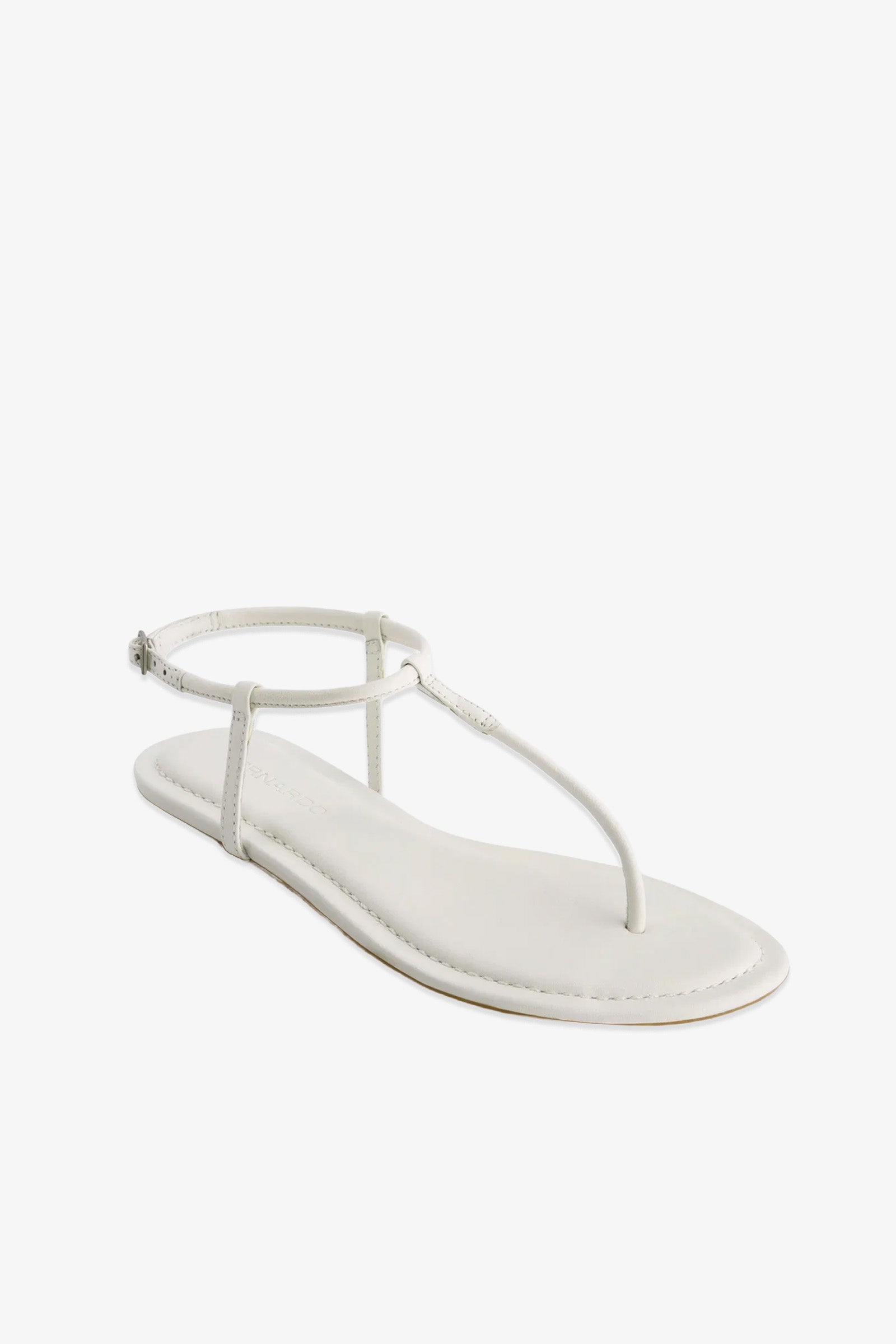 The Hercu Sandal is a single white flat sandal featuring a thin ankle strap, a minimalist thong design, and a simple sole, displayed against a white background.