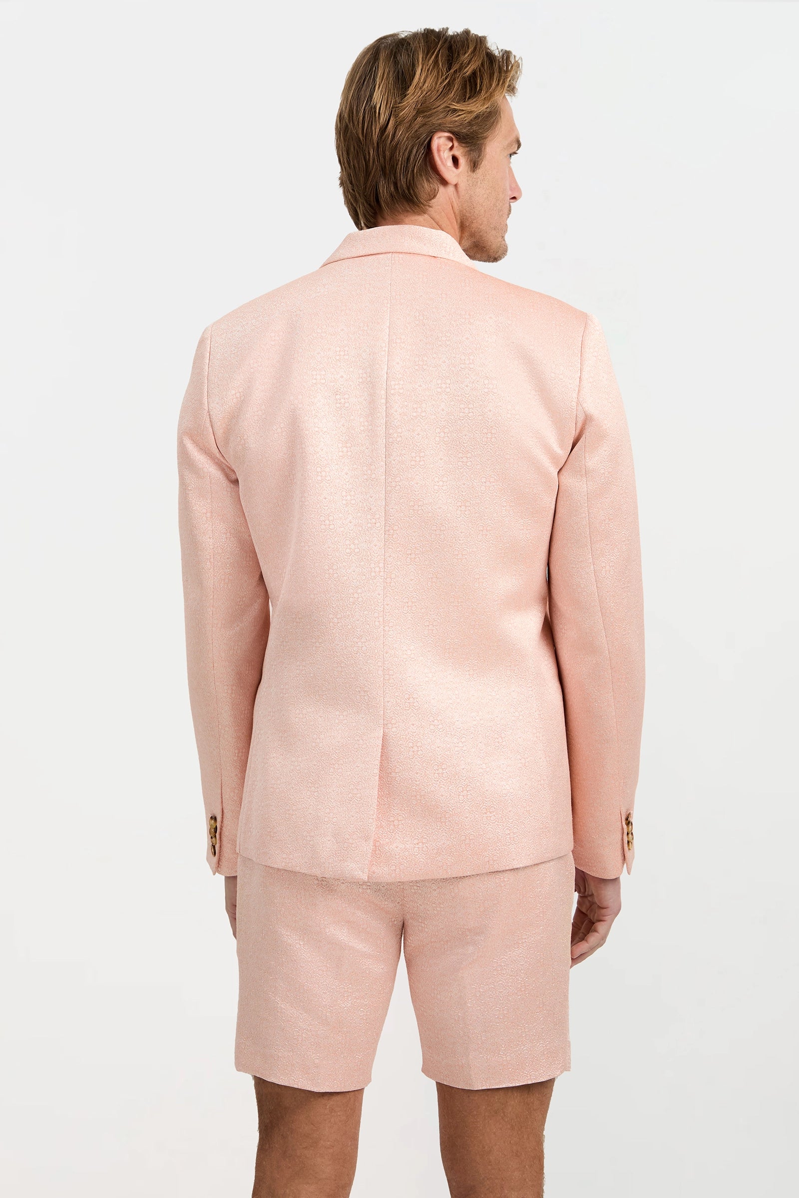 A man with light brown hair is shown from the back, wearing the Thurston Blazer - Metallic Jacquard and matching shorts with a subtle shine, set against a plain white background.
