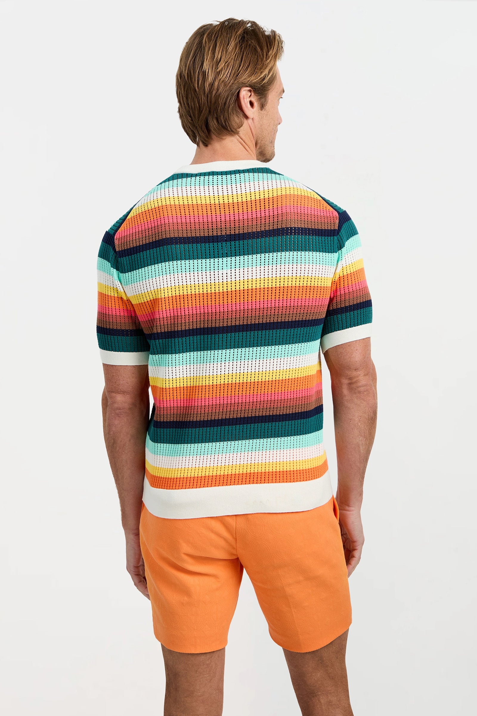 A man with light brown hair, seen from behind, wears the Carlos Short-Sleeve Mesh Crewneck and orange shorts against a plain white background.